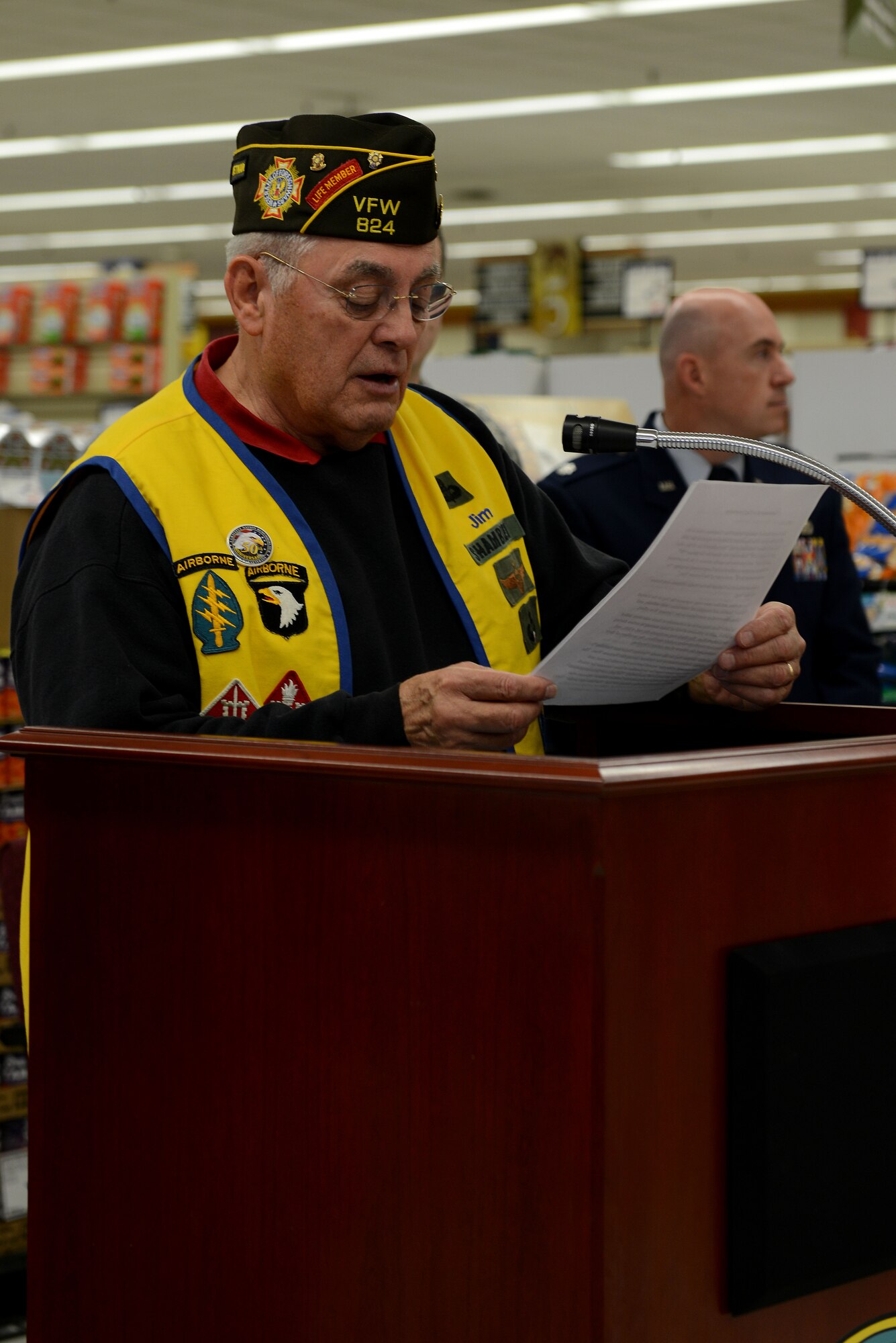 Retired U.S. Army Lt. Col. Jim Shamblem, member of Veterans of Foreign Wars Post 824, reads the description of the 50th Anniversary Vietnam War Commemoration flag at the Langley Air Force Base, Va., commissary, Nov. 9, 2013. According to the description, each decoration signifies the importance of the Vietnam War. (U.S. Air Force photo by Airman 1st Class Kimberly Nagle/Released) 