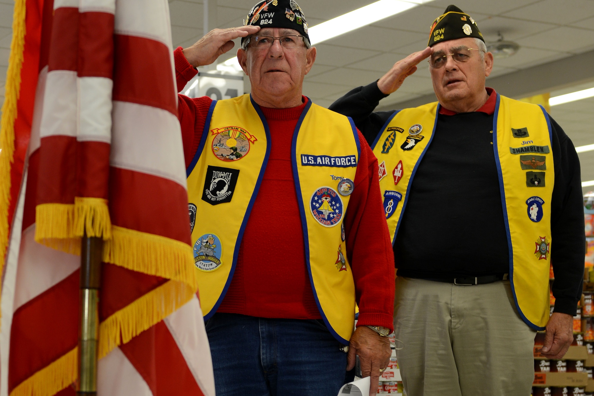 Retired Service members from Veterans of Foreign Wars Post 824 salute the American Flag during the reciting of the Pledge of Allegiance during a 50th Anniversary Vietnam War Commemoration Flag revealing at the Langley Air Force Base, Va., commissary, Nov. 9, 2013. The ceremony was held to recognize the valor and sacrifice of Service members who served in the Vietnam War, and to present a new Department of Defense-sponsored Vietnam War 50th anniversary flag. (U.S. Air Force photo by Airman 1st Class Kimberly Nagle/Released)