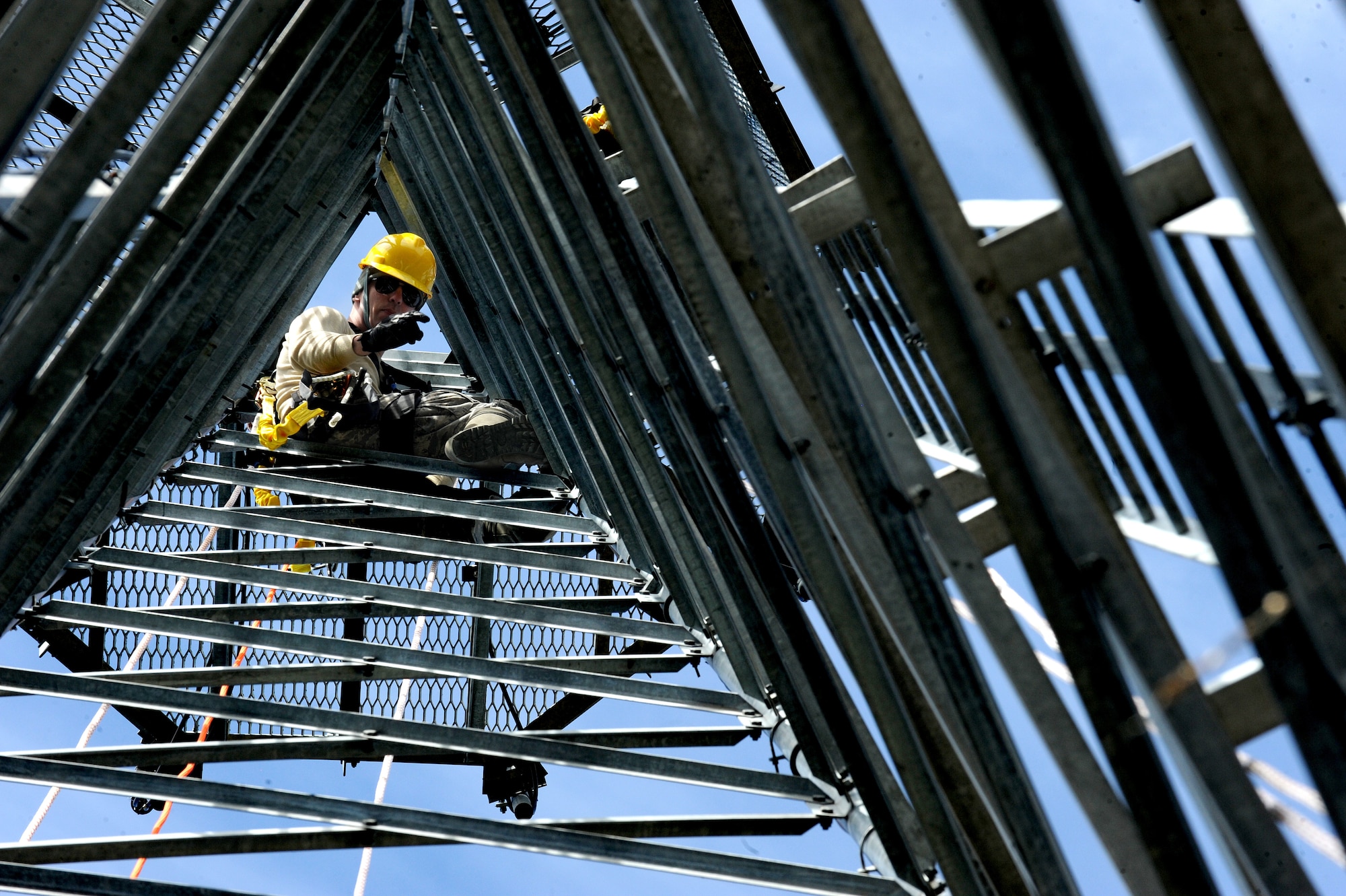 U.S. Air Force Senior Airman Mikel Columbus, 4th Communications Squadron ground radar technician, shouts climbing commands at Airmen during a training exercise at Seymour Johnson Air Force Base, N.C., Oct. 29, 2013. Airmen learned to inspect gear, tie knots and use equipment to safely maintain electronics 100 feet above the ground.  (U.S. Air Force photo by Airman 1st Class Aaron J. Jenne)