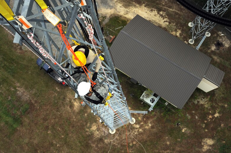 U.S. Air Force Senior Airman Mikel Columbus, 4th Communications Squadron ground radar technician, instructs Maj. Nelson Avilesfigueroa, 4th CS commander, how to safely rappel down a 100-foot tower at Seymour Johnson Air Force Base, N.C., Oct. 29, 2013. Columbus instructs Airmen during annual climbing certifications to ensure proper technique and safety. (U.S. Air Force photo by Airman 1st Class Aaron J. Jenne)