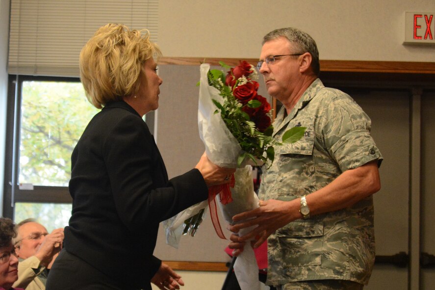 U.S. Air Force Col. Norman Brosi, the outgoing commander of the 139th Mission Support Group, Missouri Air National Guard, hands flowers to his wife during a change of command ceremony at Rosecrans Air National Base, Mo., Oct. 18, 2013. Lt. Col. Gordon Meyer takes the place of Brosi, who retires next week. (U.S. Air National Guard photo by Tech. Sgt. Michael Crane/Released)