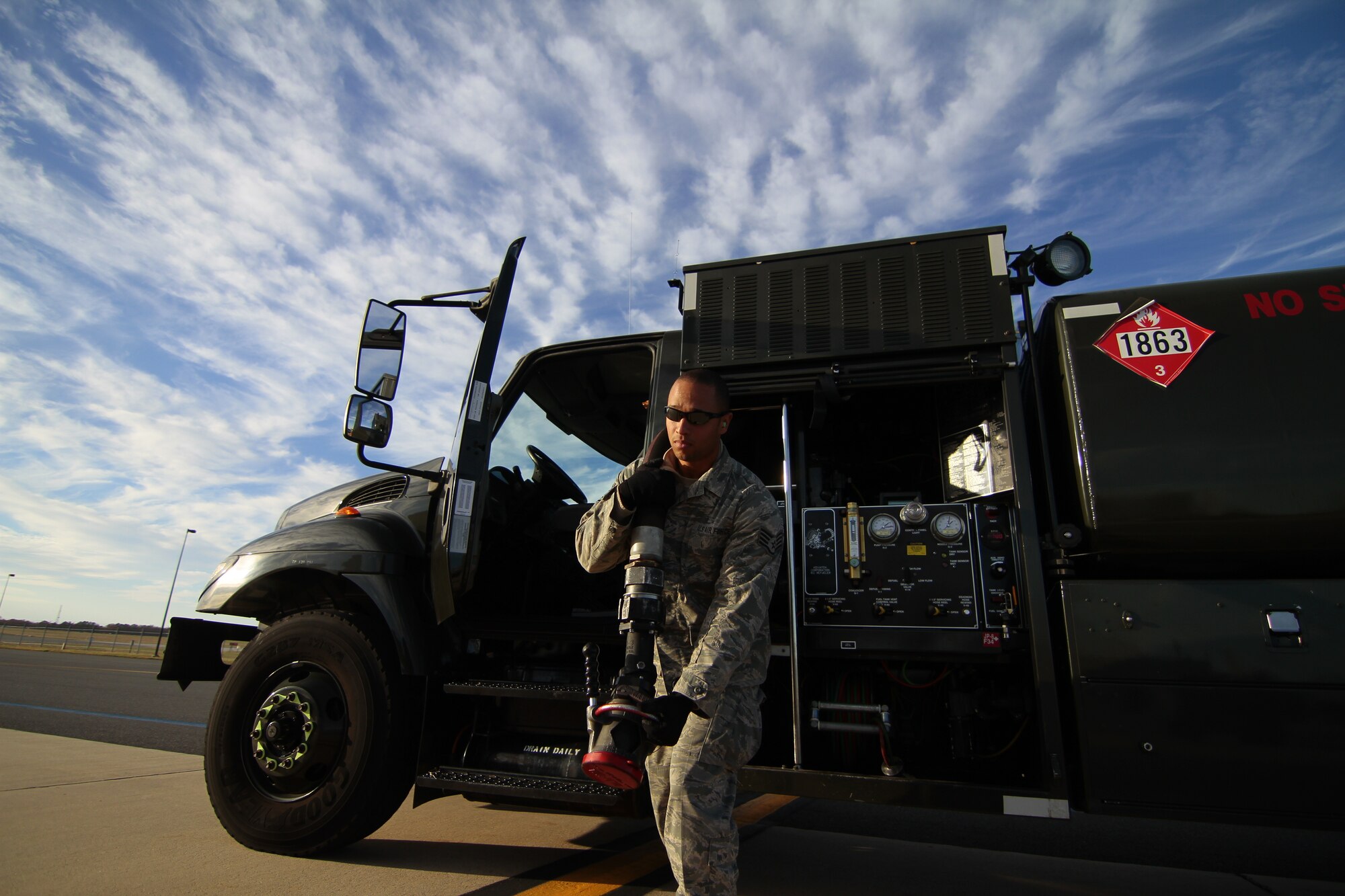 A picture of U.S. Air Force Staff Sgt. Alexander Hunter III pulling a hose from an R-11 refueling truck.