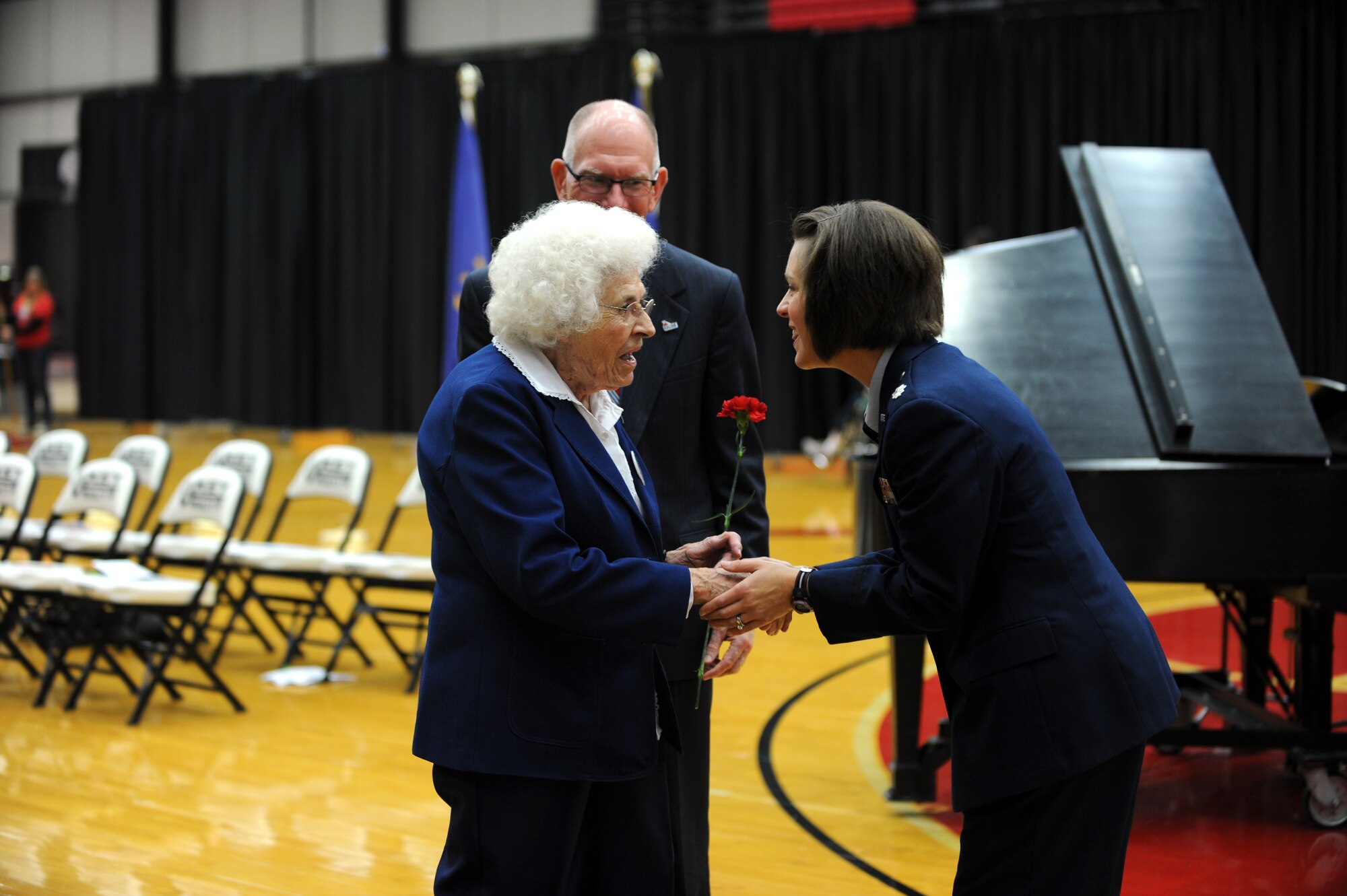 U.S. Air Force Lt. Col. Beth Makros, 394th Combat Training Squadron commander from Whiteman Air Force Base, Mo., shakes the hand of a U.S. Navy veteran Nov. 11, 2013, at the University of Central Missouri’s Veterans Day ceremony in Warrensburg, Mo. Each female veteran was presented with a carnation in recognition of her contributions. (U.S. Air Force photo by Staff Sgt. Brigitte N. Brantley/Released)