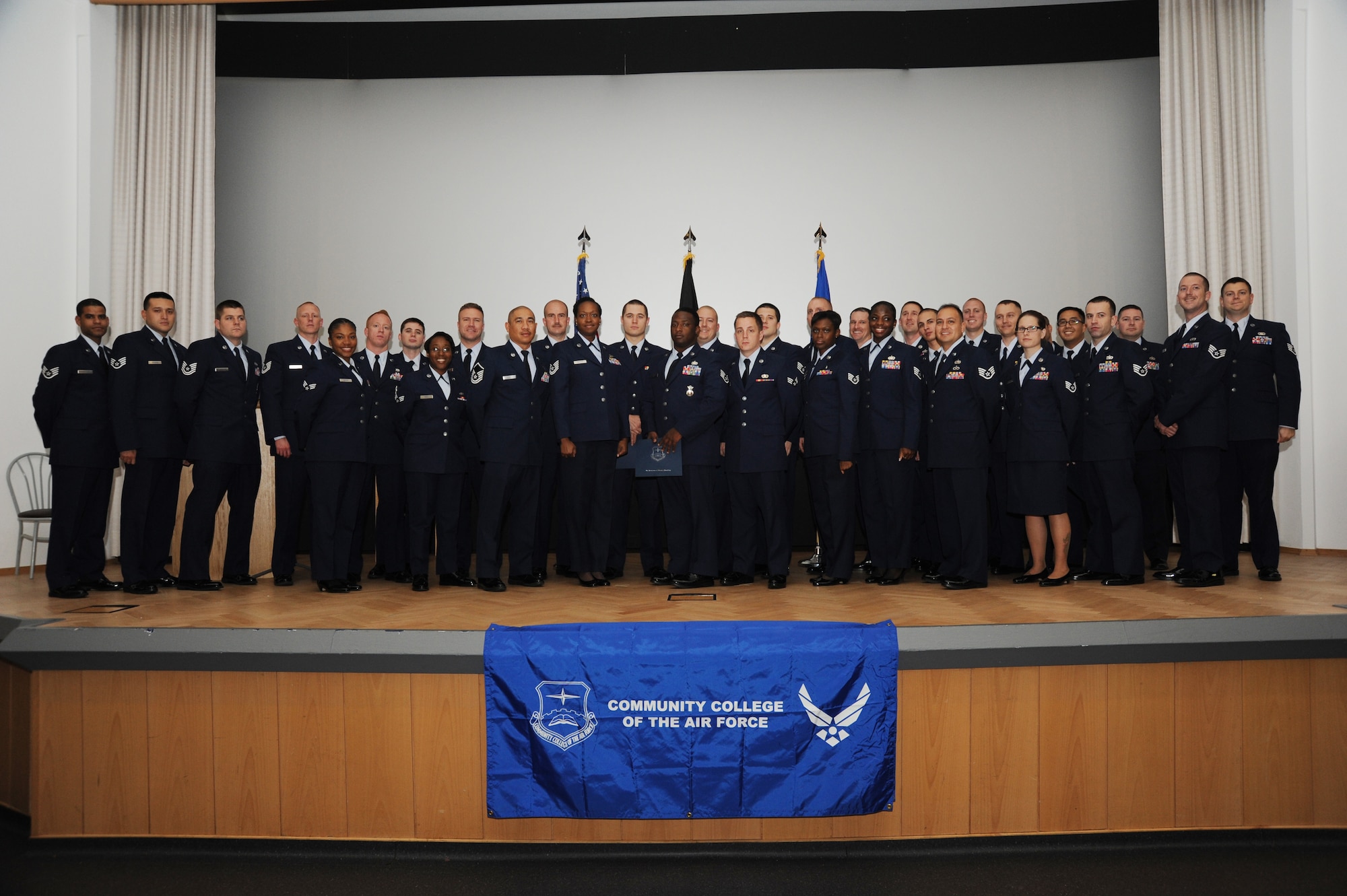SPANGDAHLEM AIR BASE, Germany --- Community College of the Air Force graduates pose with 52nd Fighter Wing Leadership for a group photo during a graduation ceremony at the base theater Nov. 12. Nearly 100 Spangdahlem Airmen received their associate degrees through the CCAF during the past year. (U.S. Air Force photo by Airman 1st Class Dylan Nuckolls/Released)