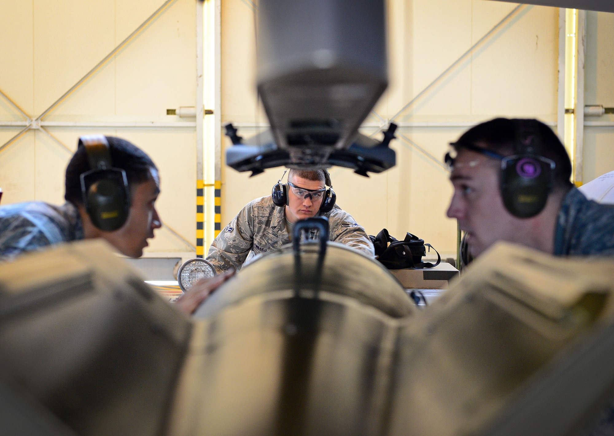 (From left) Staff Sgt. Angelo Cepeda, Airman 1st Class Randall Stoiner and Airman 1st Class William Miller, 31st Aircraft Maintenance Squadron weapons load crew members, attach ordnance to an F-16 Fighting Falcon, Nov. 6, 2013, at Aviano Air Base, Italy. The 31st Munitions Squadron weapons load crew members are responsible for loading and unloading munitions. (U.S. Air Force photo/Senior Airman Matthew Lotz)