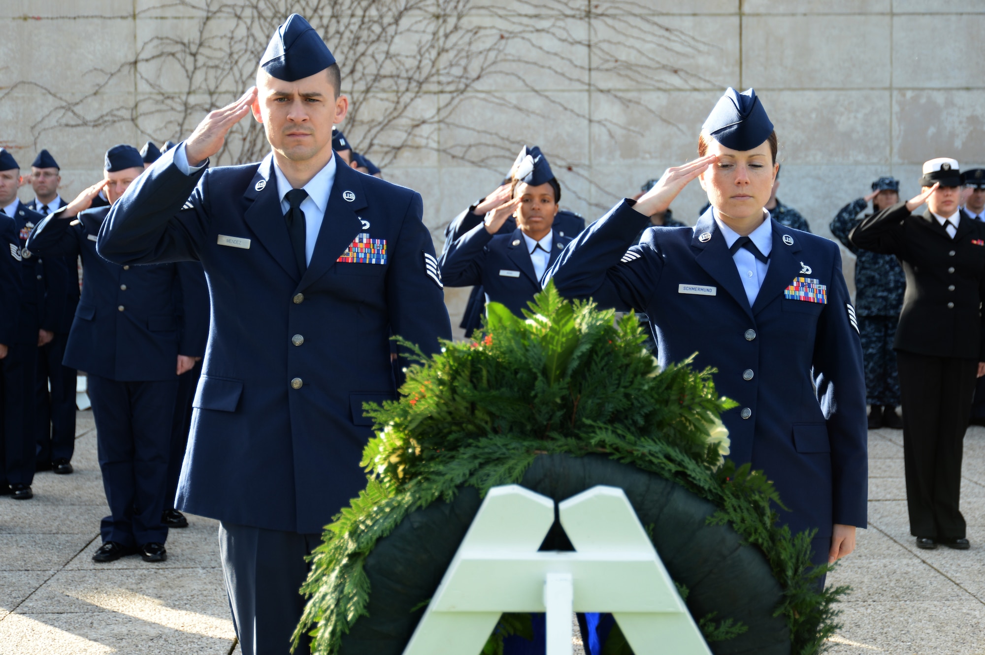 HOMBOURG, Belgium --- U.S. Air Force Staff Sgts. Miles Mendez and Jennifer Schmermund, both of 52nd Civil Engineer Squadron at Spangdahlem Air Base, Germany, salute along with fellow service members during a Veterans Day memorial ceremony at the Henri-Chapelle American Cemetery Nov. 11, 2013. More than 40 service members participated in the ceremony to honor the service and sacrifice of American veterans. (U.S. Air Force photo by Staff Sgt. Joe W. McFadden/Released)