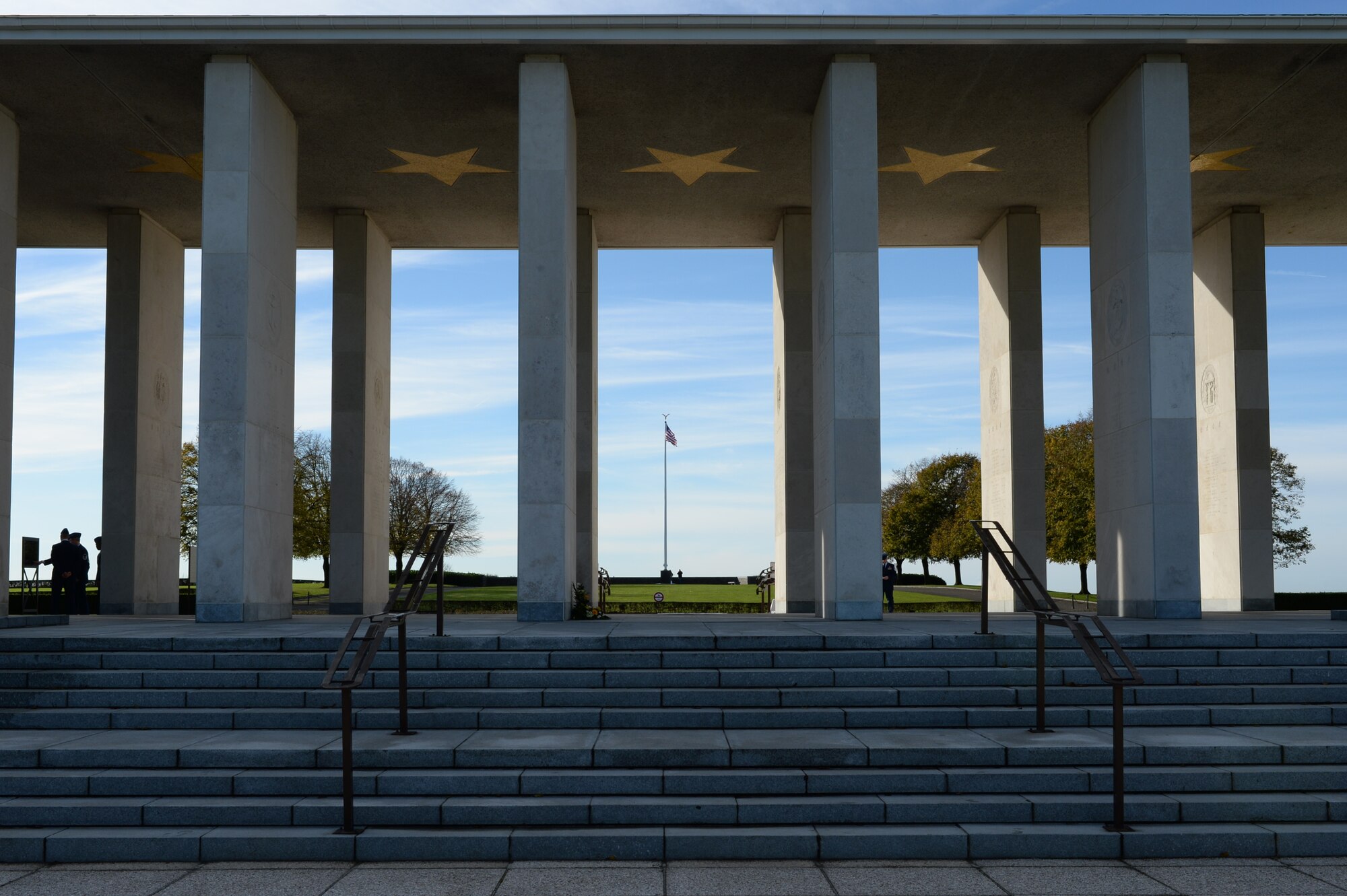 HOMBOURG, Belgium --- A promenade adorned with 13 golden stars and pillars representing the American states and territories stands at the Henri-Chapelle American Cemetery Nov. 11, 2013. The walls of the promenade are lined with the names of more than 400 American service members who are listed as missing while serving in World War II. (U.S. Air Force photo by Staff Sgt. Joe W. McFadden/Released)