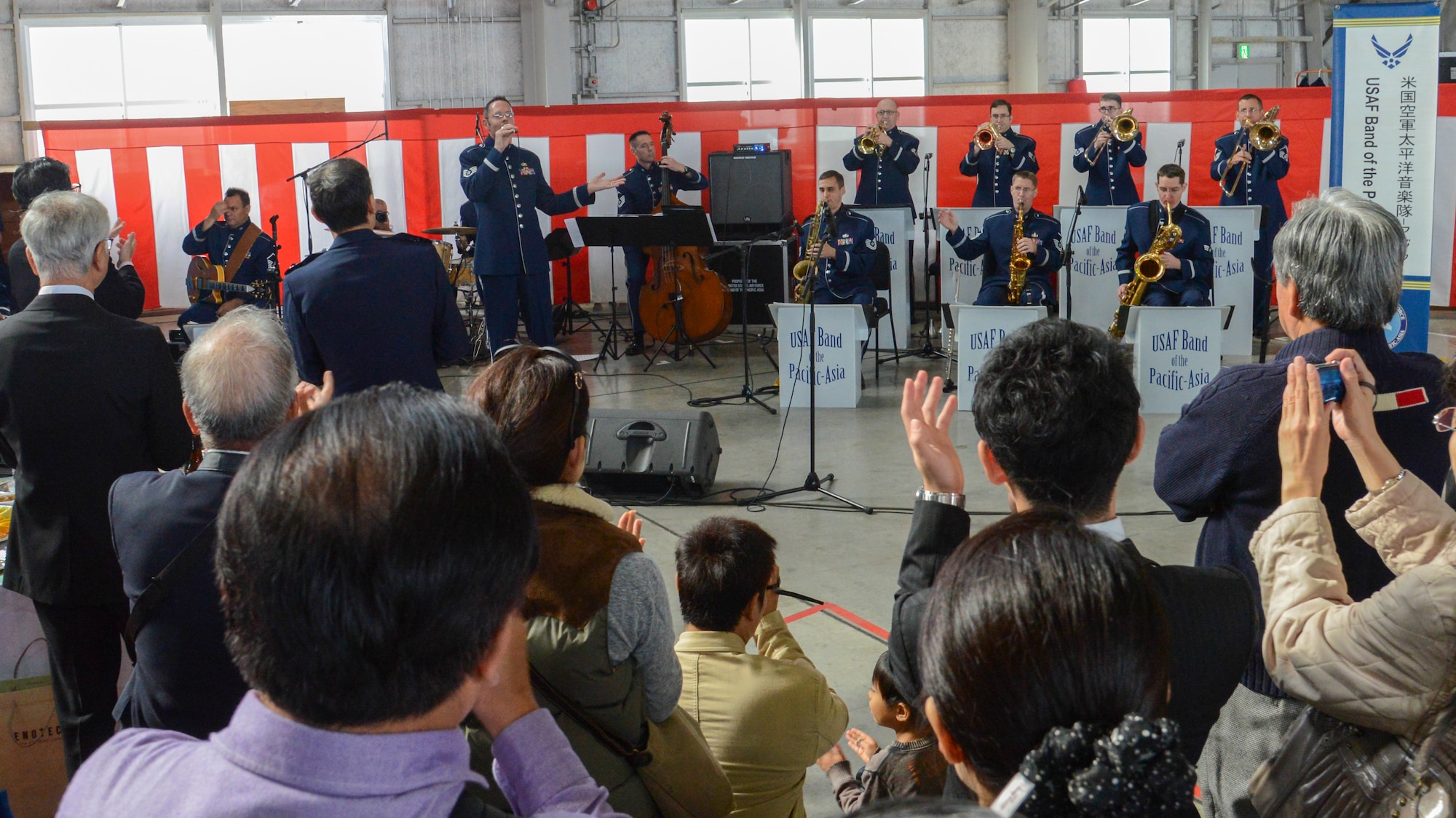 A crowd cheers as the Pacific Air Forces Band finishes their performance at Iruma Air Base, Japan, Nov. 3, 2013. The PACAF Band were one of many Yokota members invited to the annual Iruma Air Show.  (U.S. Air Force photo by Airman 1st Class Soo C. Kim / Released)