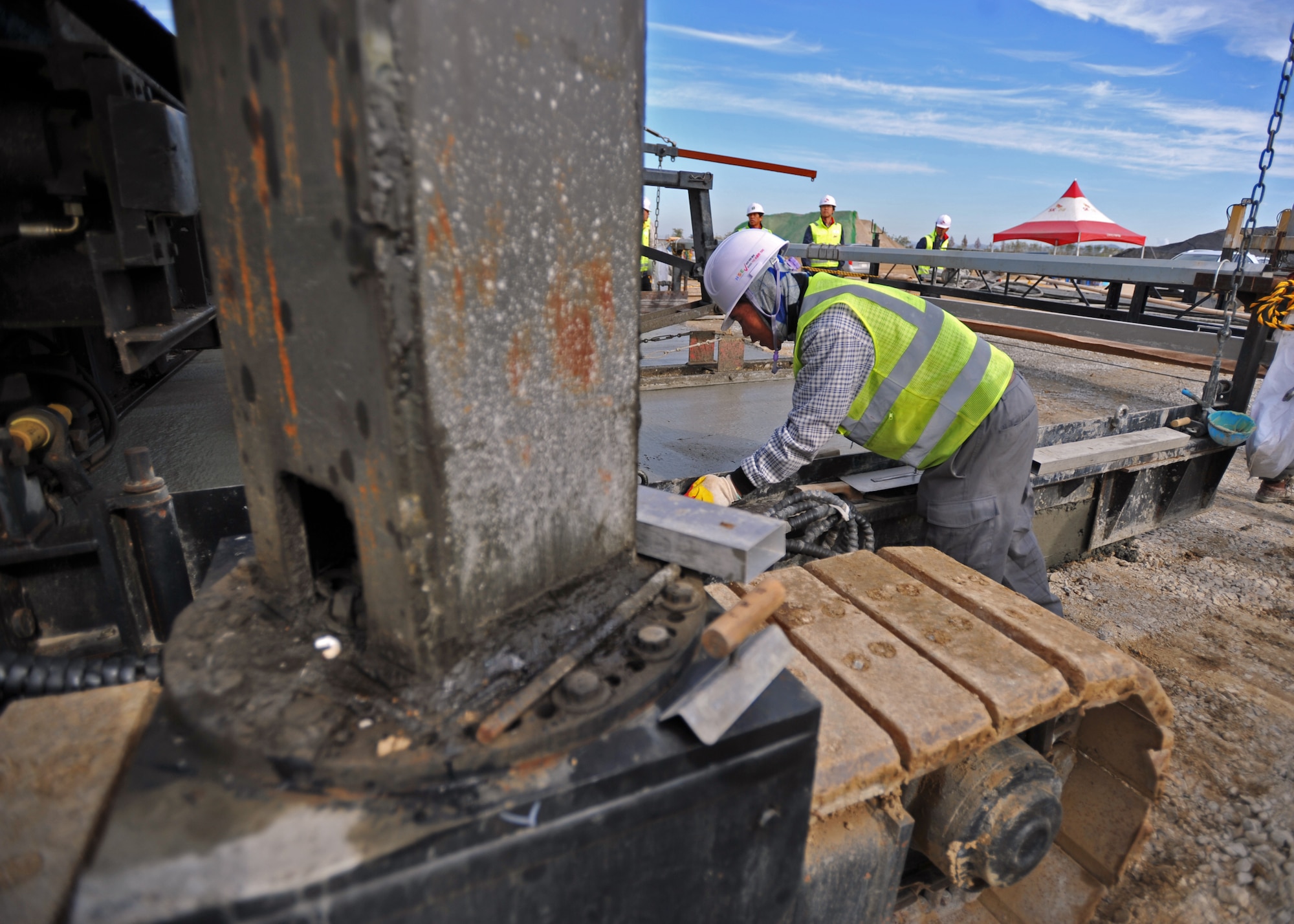 A construction worker smooths out the first section of the second runway at Osan Air Base, Republic of Korea, Nov. 8, 2013. Prior to the actual paving, construction debris, topsoil and other debris found at the site was safely removed, transported and disposed of at a designated safe location off base. (U.S. Air Force photo/Senior Airman Siuta B. Ika)