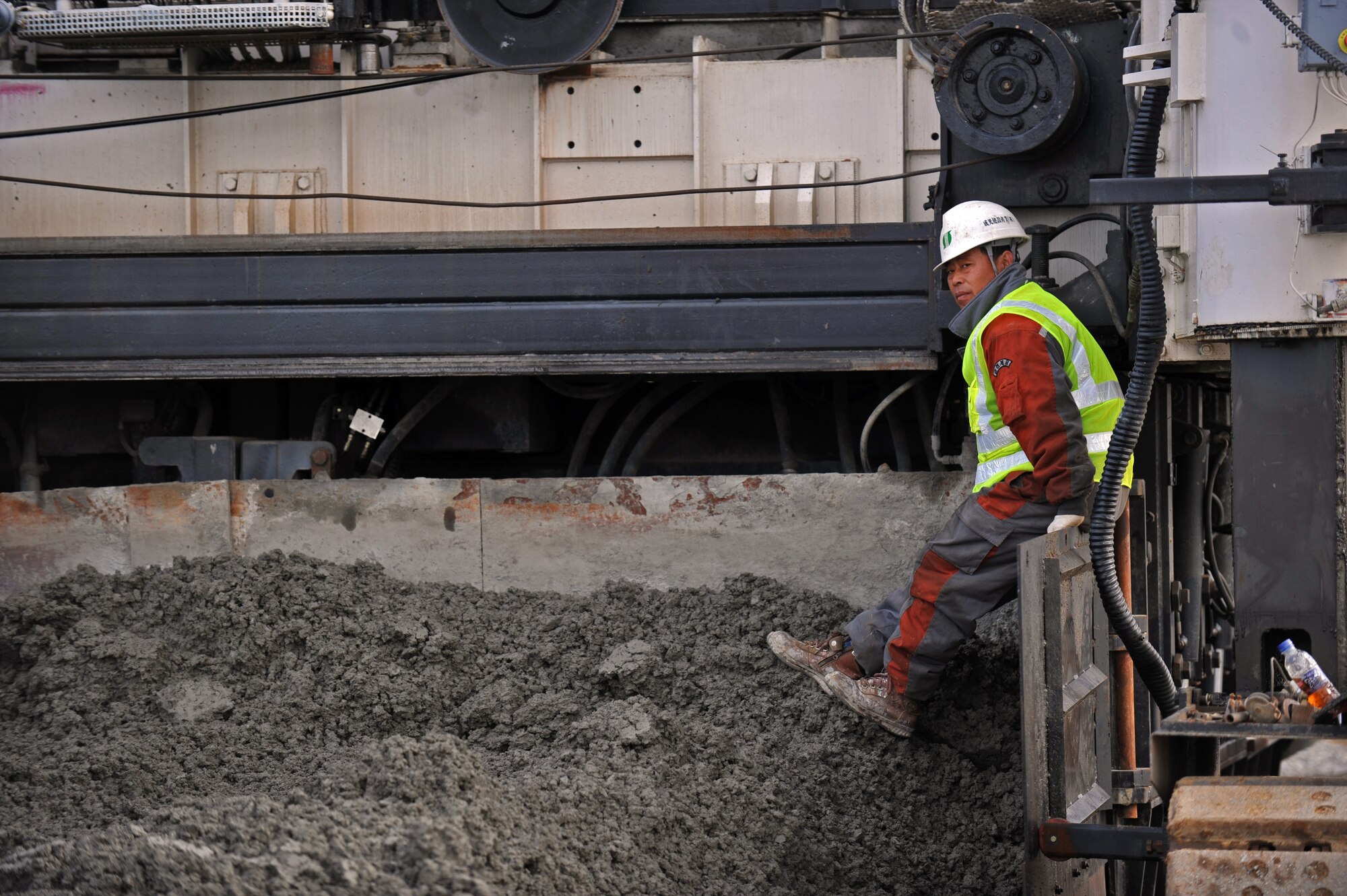 A construction worker waits for a dump truck to unload special cement mix at Osan Air Base, Republic of Korea, Nov. 8, 2013. This particular batch of cement mix was used to pave the first section of Osan’s second runway. (U.S. Air Force photo/Senior Airman Siuta B. Ika)