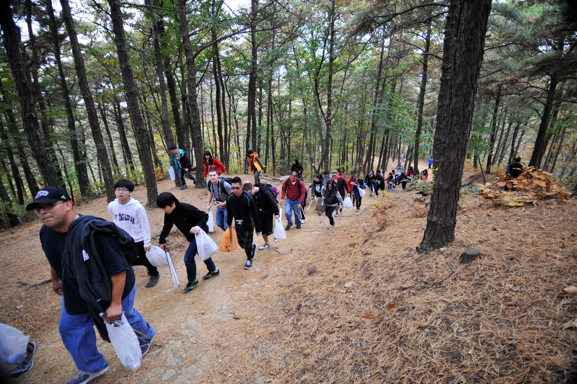 Troops for Trash volunteers keep an eye out for trash while hiking up Buraksan Mountain, Republic of Korea, Nov. 9, 2013. Every second Saturday of the month, rain or shine, volunteers gather by the Main Gate to begin the eight-mile hike. (U.S. Air Force photo/Staff Sgt. Emerson Nuñez)