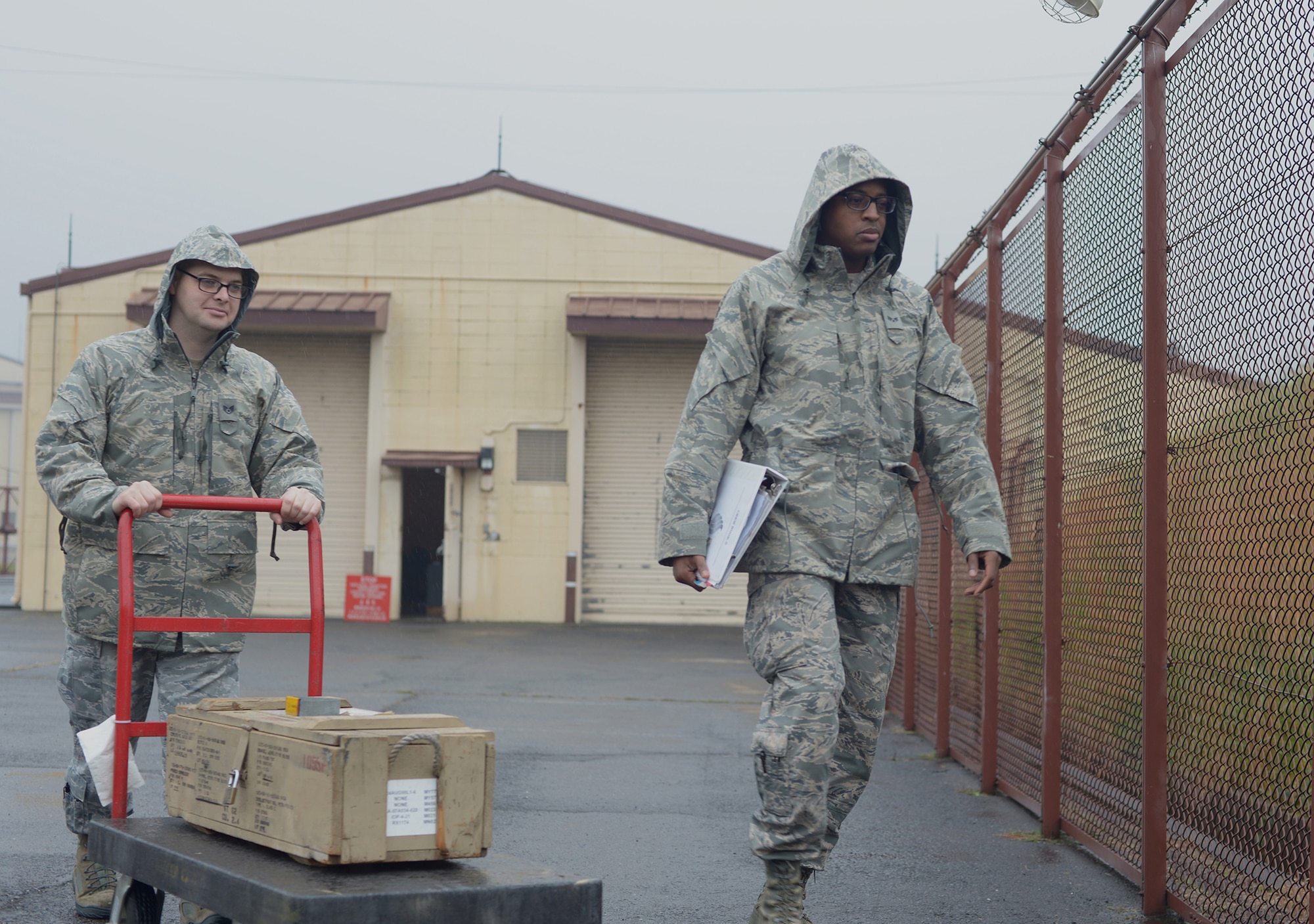 Staff Sgt. Samuel Percy and Senior Airman Joshua James, 374th Maintenance Squadron, escort explosive materials to the storage bunker at Yokota Air, Japan, Nov. 7, 2013. Proper storage is an important safety measure and ensures the materials a longer shelf life. (U.S. Air Force photo by Airman 1st Class David Danford/Released)