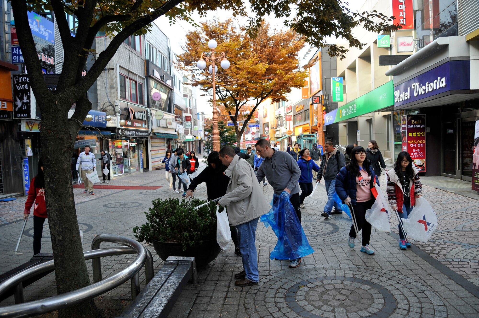 Troops for Trash volunteers search for trash to pick up in the Songtan Entertainment District, Republic of Korea, Nov. 9, 2013. After 40 hours of volunteer time, a certificate and coin are presented to the volunteer and they are then made official Korean American Partnership Association members. (U.S. Air Force photo/Staff Sgt. Emerson Nuñez)