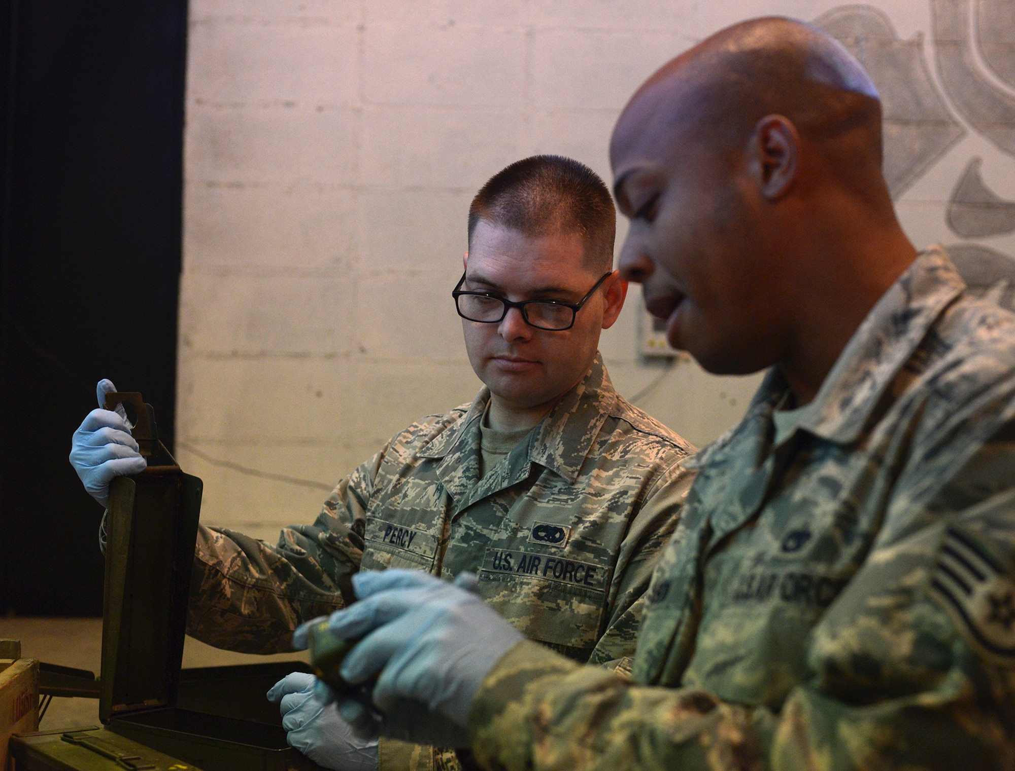 Staff Sgts. Samuel Percy and James Stinson, 374th Maintenance Squadron, check explosive materials from the K-9 training kit at Yokota Air Base, Japan, Nov. 7, 2013. Heavily damaged materials must be replaced to ensure the safety of security forces and their military working dogs. (U.S. Air Force photo by Airman 1st Class David Danford/Released)