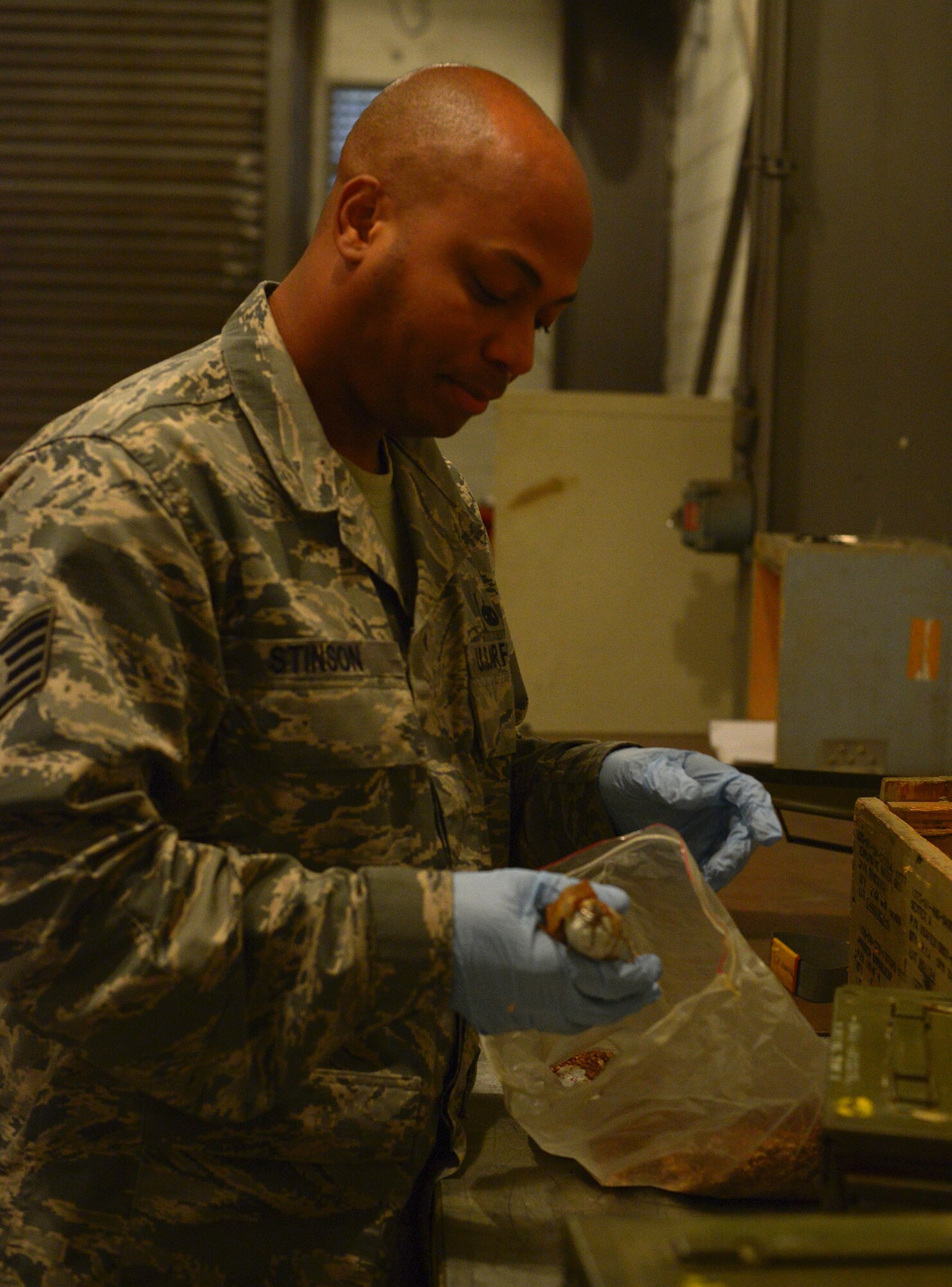 Staff Sgt. James Stinson, 374th Maintenance Squadron senior munitions inspector, checks explosives from the K-9 training kit for punctures at Yokota Air Base, Japan, Nov. 7, 2013. Munitions inspectors are not only tasked with identifying damaged materials but also repairing them when possible. (U.S. Air Force photo by Airman 1st Class David Danford/Released)