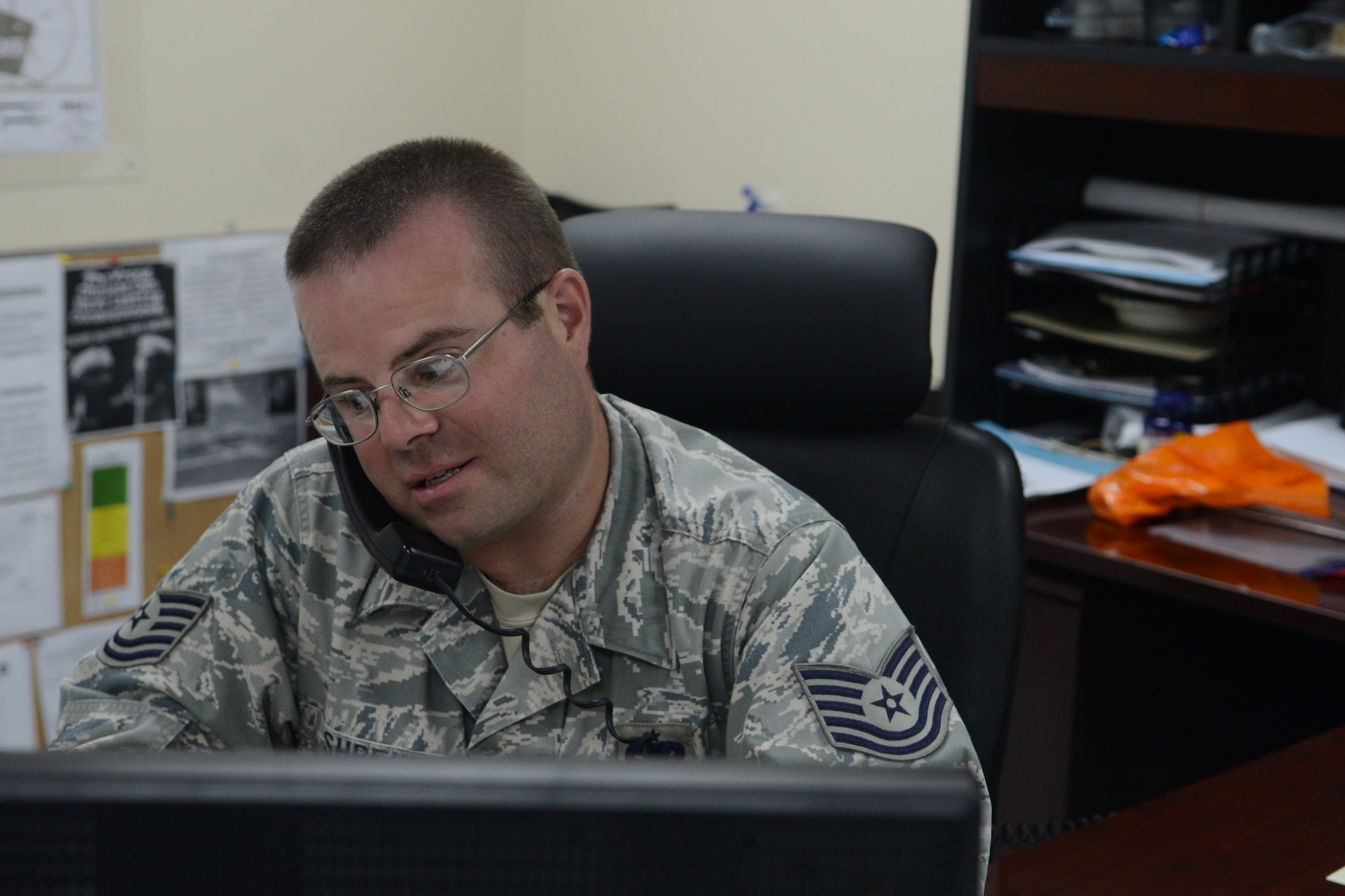 Tech. Sgt. James Shreve, 36th Maintenance Group section chief of programs and resources, works on the integrated maintenance database system while speaking to a customer Nov. 12, 2013, on Andersen Air Force Base, Guam. The inactivation of the flight is part of an Air Force-wide initiative to better align maintenance objectives for the future fiscal years. (U.S. Air Force photo by Airman 1st Class Emily A. Bradley/Released)