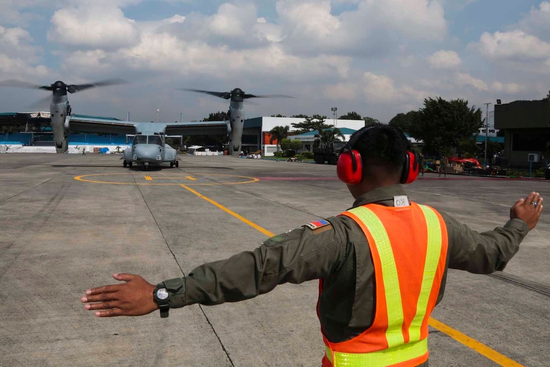 Philippine Air Force Airman 1st Class Herom Rabago, assigned to the 520th Air Base Wing, guides a MV-22B Osprey carrying supplies and personnel from Villamor Air Base, Manila, to areas affected by Typhoon Haiyan, Nov. 14. The U.S. and Philippine Armed Forces have transported more than 384,400 pounds of relief supplies and more than 1,735 displaced personnel. The militaries of the two nations have partnered and trained together for decades, which prepare both forces for the challenges associated with extreme circumstances. (U.S. Marine Corps photo by Lance Cpl. Caleb Hoover)