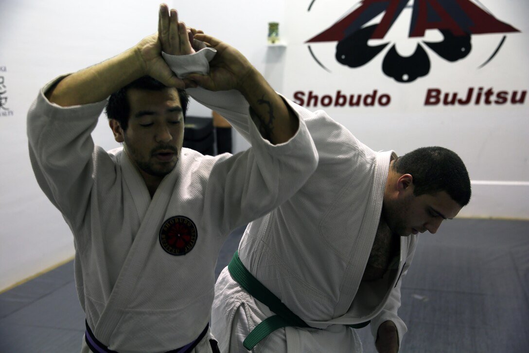 Xavier Turcotte, a Jujitsu instructor, teaches Jujitsu students how to apply an arm bar to Nick Dowden, a Jujitsu student, during a class at building 39, next to the Goettge Memorial Field House, aboard Marine Corps Base Camp Lejeune, Nov. 7. Classes are held Tuesdays and Thursdays from 6:30 p.m. to 9 p.m.