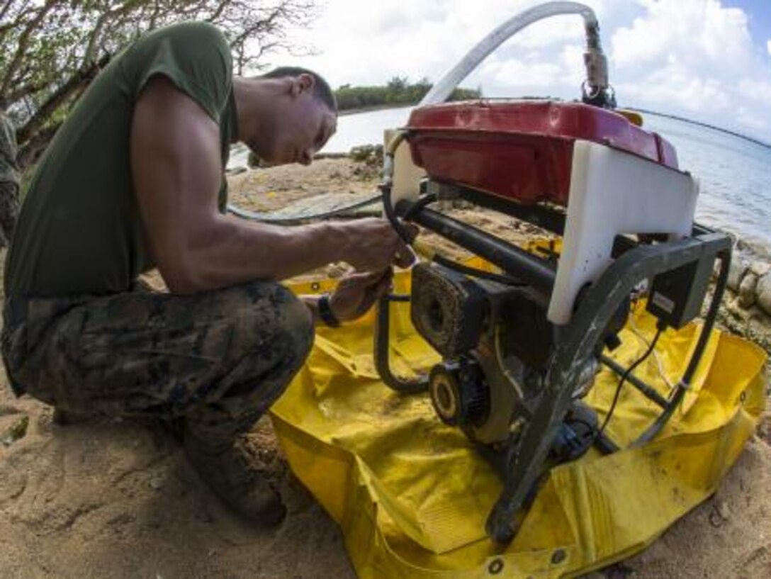 Lance Cpl. Dean O. Barrett, from San Diego, Calif., attaches hoses to a tactical water purification system’s fuel pump Nov. 6, 2013, around a beach area on Tinian to provide Marines a potable water source during exercise Forager Fury II. Barrett is a water support technician with Marine Wing Support Squadron 171, Marine Aircraft Group 12, 1st Marine Aircraft Wing, III Marine Expeditionary Force.