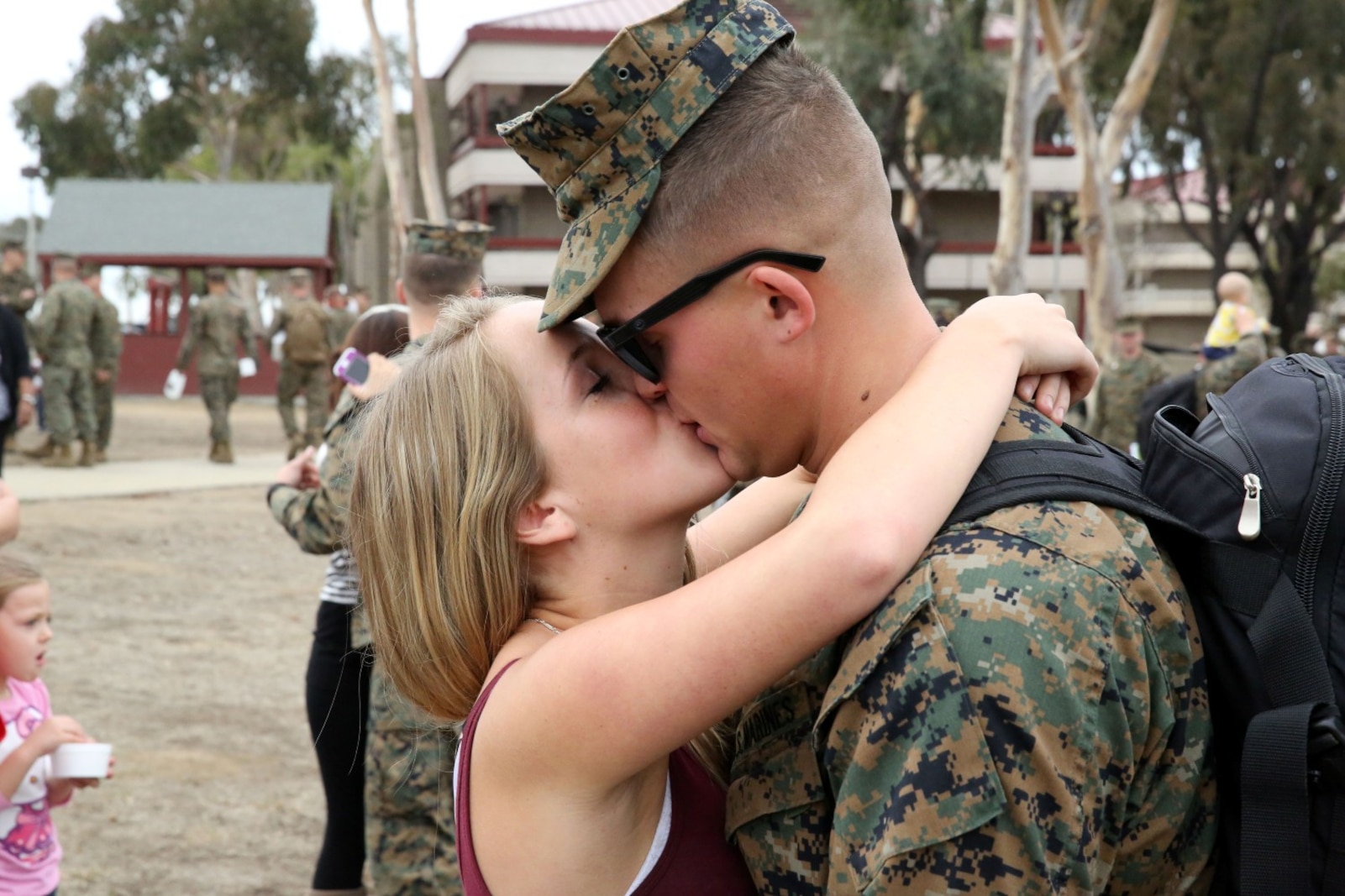 Corporal Tristen Arnold, amphibious assault vehicle crewman, Echo Company, 3rd Assault Amphibian Battalion, and native of New Cumberland, Pa., kisses his girlfriend, Alison Rombach, before his upcoming deployment to Okinawa, Japan, here, Nov. 12, 2013. Families of the Echo Co. Marines gathered to say goodbye as they left for their six-month deployment. Family day helps the families of Marines get together and support each other while their loved ones are deployed.