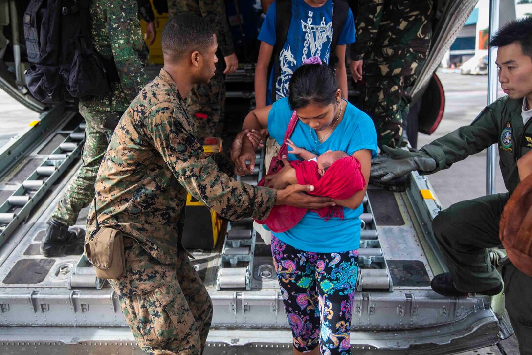 U.S. Marine Lance Cpl. Xavier L. Cannon and members of the Philippine Armed Forces help civilians displaced by Typhoon Haiyan disembark a C-130 aircraft Nov. 13 at Villamor Air Base as part of Operation Damayan. The U.S. and Philippine Armed Forces have transported more than 107,000 pounds of relief supplies, 140 relief and aid workers, and more than 160 displaced personnel. The militaries of the two nations have partnered and trained together for decades, which prepare both forces for the challenges associated with extreme circumstances. Approximately 300 personnel from 3rd Marine Expeditionary Brigade have deployed in support of the relief efforts being orchestrated by the Government of the Philippines. (U.S. Marine Corps photo by Lance Cpl. Anne K. Henry/RELEASED)

