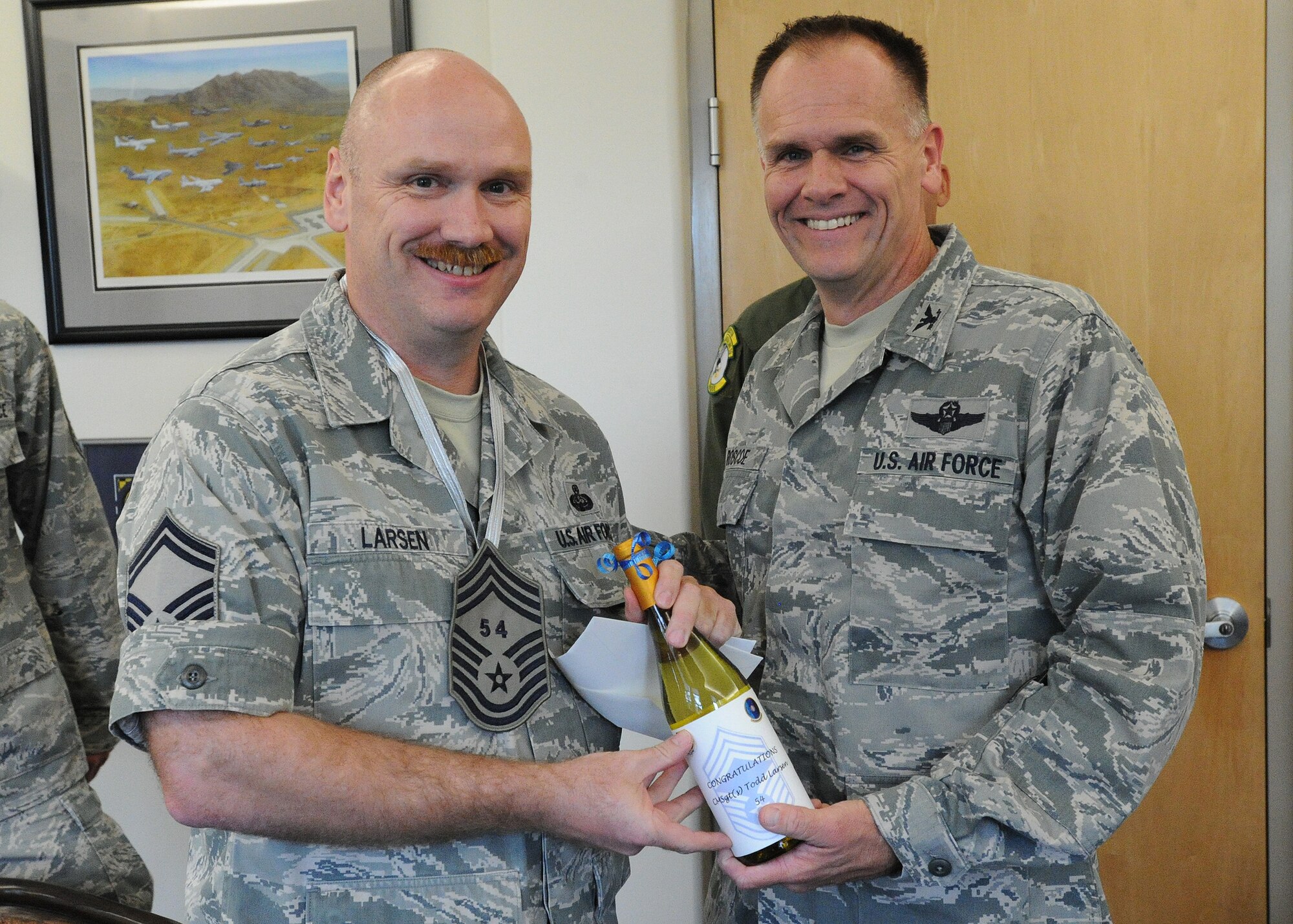 Senior Master Sgt. Todd Larsen, 747th Communications Squadron flight chief, accepts a congratulatory letter and promotion memento this week shortly after being notified of his promotion to chief master sergeant by Col. Johnny Roscoe, 15th Wing commander, at 15th Wing headquarters building, at Joint Base Pearl Harbor-Hickam, Hawaii. (U.S. Air Force photo/Tech. Sgt. Jerome S. Tayborn)