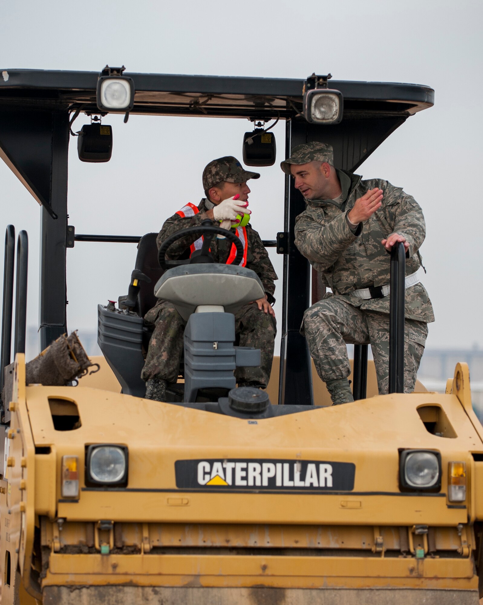 Master Sgt. Jason Lilley, 8th Civil Engineer Squadron, offers advice to a Republic of Korea airman during a combined Airfield Damage Repair Exercise at Kunsan Air Base, ROK, Nov. 14, 2013. The exercise with ROK air force's 1st Civil Engineer Squadron allowed members of both air forces to work together, learn different methods and become more proficient with airfield repairs. (U.S. Air Force photo by Senior Airman Clayton Lenhardt/Released)