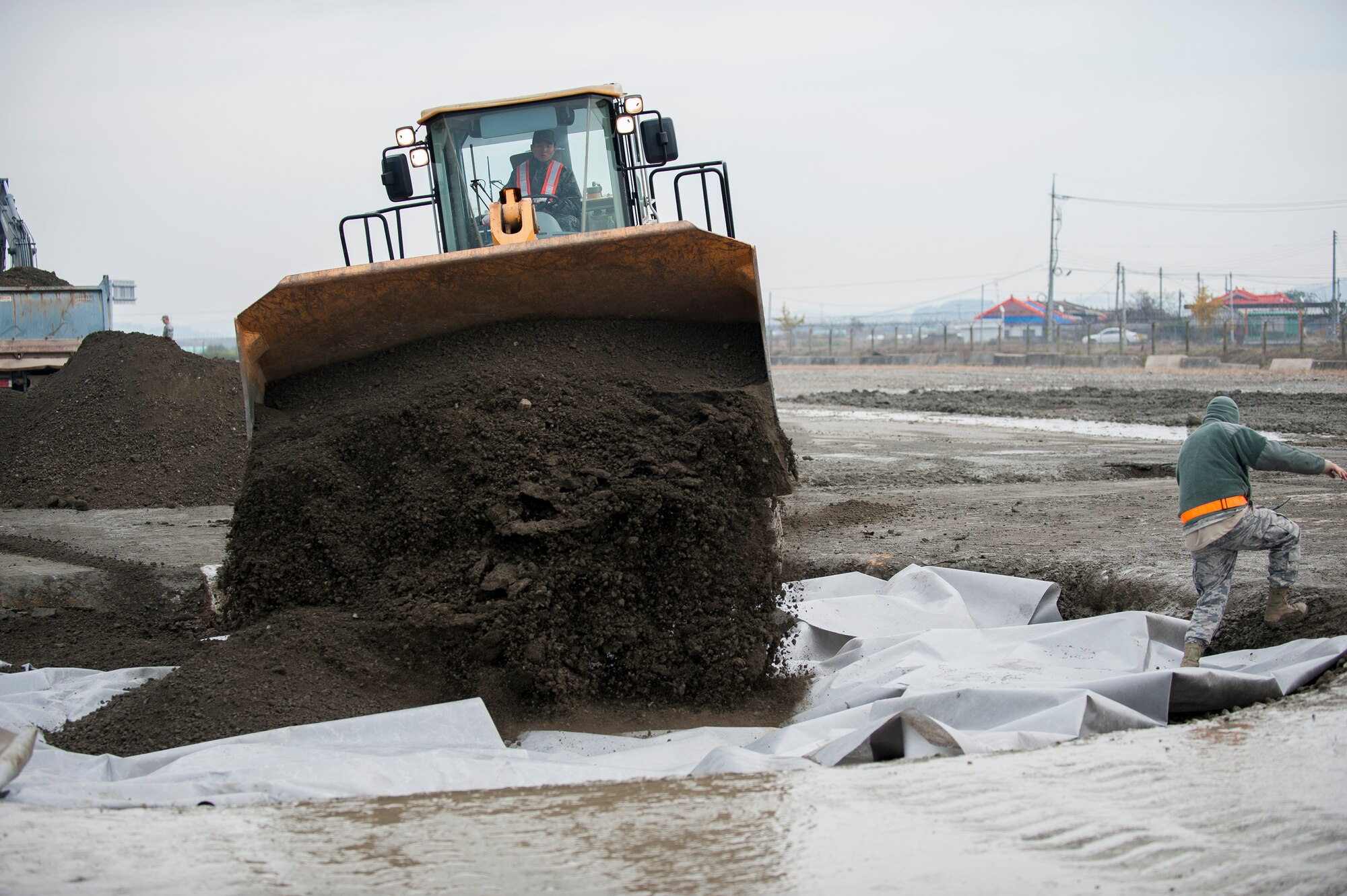 A Republic of Korea air force airman from the 1st Civil Engineer Squadron applies the top layer of dirt during a combined Airfield Damage Repair Exercise at Kunsan Air Base, ROK, Nov. 14, 2013. The exercise allowed members of both air forces to work together, learn different methods and become more proficient with airfield repairs. (U.S. Air Force photo by Senior Airman Clayton Lenhardt/Released)