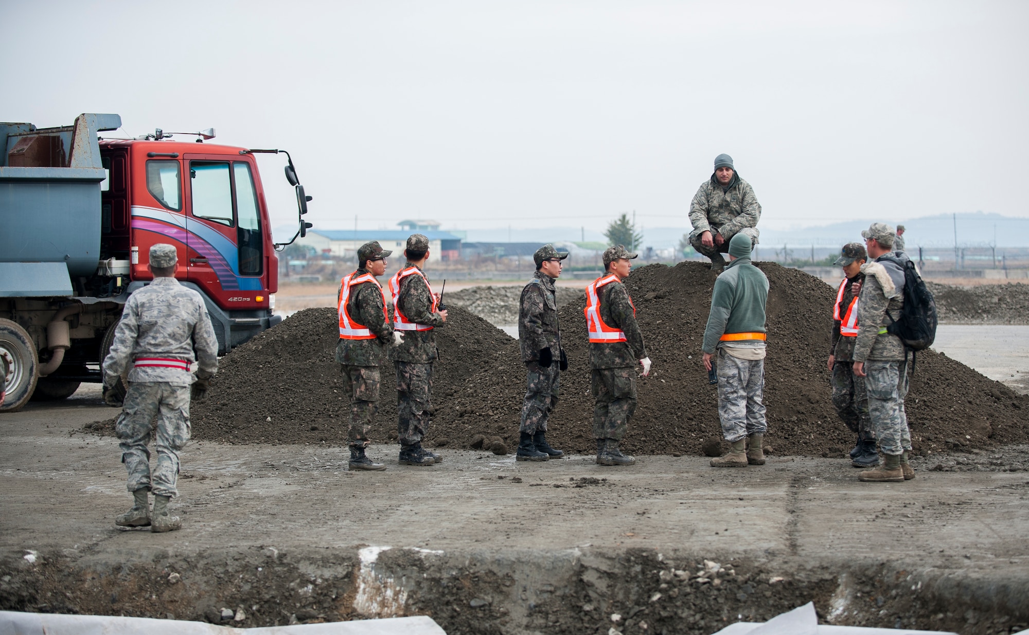 U.S. Air Force Airmen from the 8th Civil Engineer Squadron and Republic of Korea airmen from the 1st CES gather during a combined Airfield Damage Repair Exercise at Kunsan Air Base, ROK, Nov. 14, 2013. The exercise allowed members of both air forces to work together, learn different methods and become more proficient with airfield repairs. (U.S. Air Force photo by Senior Airman Clayton Lenhardt/Released)