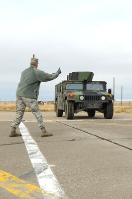 Lt. Col. Michael Calvaresi, 10th Missile Squadron commander, acts as the “flagger” during the first Humvee Olympics at the skid and gravel course on the Malmstrom Air Force Base flightline on Nov. 8. Calvaresi suggested the event after conducting a similar one as the safety officer at F.E. Warren Air Force Base, Wyo. (U.S. Air Force photo/Senior Airman Katrina Heikkinen)