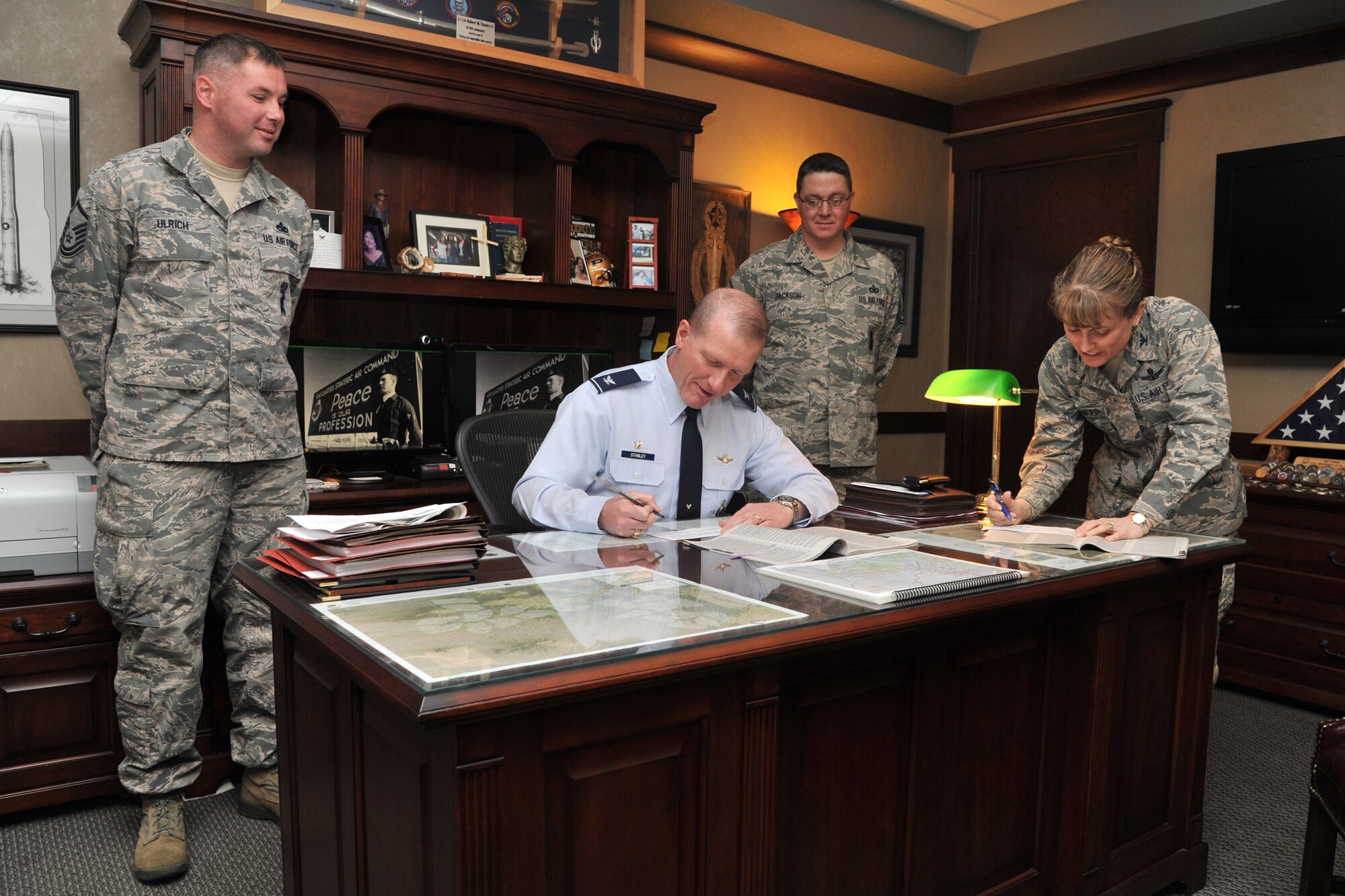 Master Sgts. Edgar Ulrich, (left) and Travis Jackson (center), 341st Missile Wing Combined Federal Campaign representatives, stand behind Col. Robert Stanley, 341st MW commander, and Col. Marné Deranger, 341 MW vice commander, as they sign their CFC pledge forms Nov. 12.  According to the campaign’s website, CFC is the world’s largest annual workplace charity campaign, with nearly 200 CFC campaigns throughout the country and overseas raising millions of dollars every year (U.S. Air Force photo / John Turner)