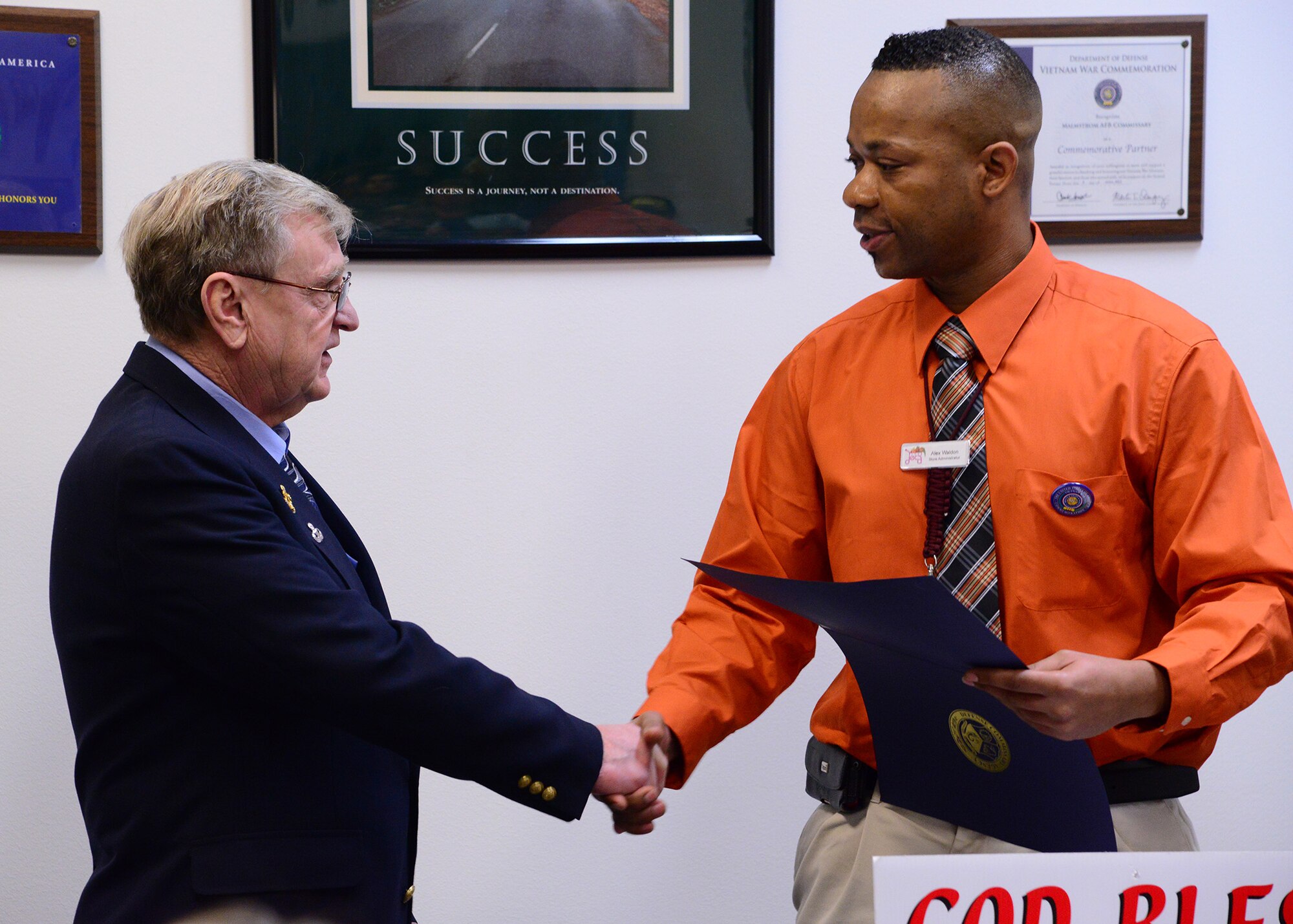 Alex Waldon (right), Malmstrom Commissary store administrator, presents a certificate of appreciation to 1st Sgt. Raymond Lutz, (ret.) and Vietnam War veteran, Nov. 8. The ceremony was held in conjunction with the United States of America Vietnam War Commemoration Commemorative Partner Program, which is a program designed to facilitate federal, state and local communities in honoring Vietnam War veterans. (U.S. Air Force photo/Airman 1st Class Collin Schmidt)