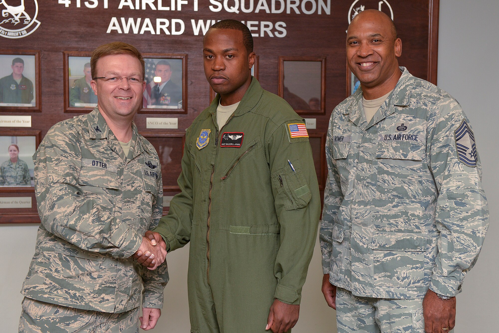 Staff Sgt. Maxwell Jones, a 41st Airlift Squadron loadmaster, is congratulated by Col. William Otter, 19th Airlift Wing vice commander, and Chief Master Sgt. Eric Rower, 19th Mission Support Group command chief, for his selection as Combat Airlifter of the Week Nov. 12, 2013, at Little Rock Air Force Base, Ark. Jones, a Norfolk, Va. native, provided safe airlift during aeromedical evacuation mission to five stateside locations, returning 13 wounded warriors home. (U.S. Air Force photo by Staff Sgt. Russ Scalf)