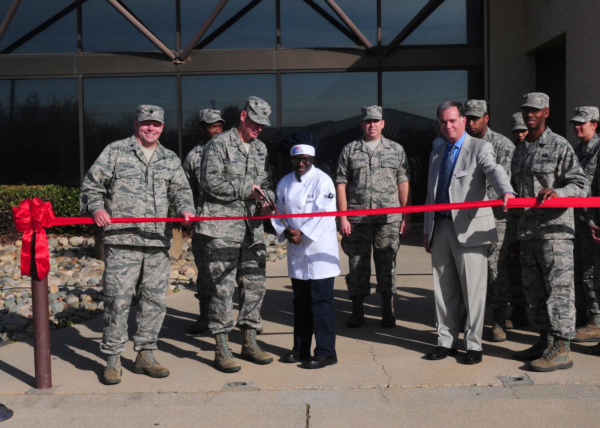 Col. Quinn Gummel (left), 9th Reconnaissance Wing vice commander, and Airman Deven Hamlet, 9th Force Support Squadron food services, cut the ribbon during the Contrails Dining Facility  grand reopening ceremony along with members from the 9th FSS and Sodexo at Beale Air Force Base, Calif., Nov. 14, 2013. The 9th FSS and Sodexo teamed up to promote health and wellness by providing nutritious food, and make food operations more efficient. (U.S. Air Force photo by Senior Airman Allen Pollard/Released)