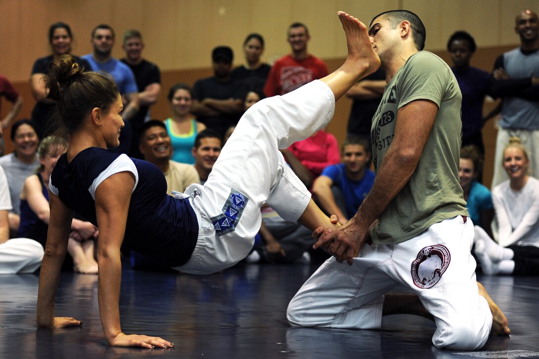 Eve Torres, Gracie Academy Women Empowered self-defense seminar instructor, demonstrates a kick drill as Rener Gracie, Gracie Academy Women Empowered self-defense seminar instructor, acts as an assailant. Gracie is a third degree black belt in Gracie Jiu-Jitsu and the second eldest grandson of Grand master Hélio Gracie, Gracie Jiu-Jitsu creator. (U.S. Air Force photo/Senior Airman Katrina Heikkinen)