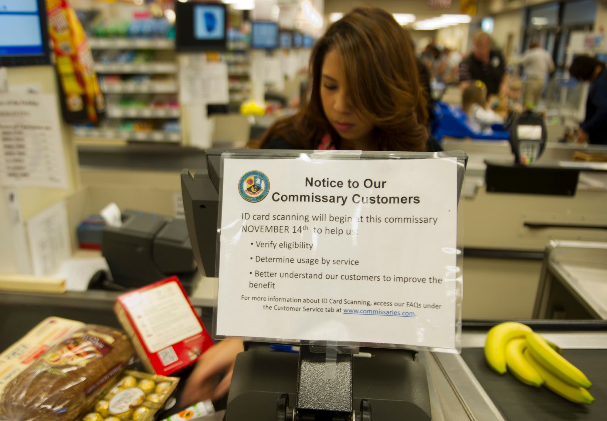 Natalie Garcia, cashier, scans a common access card prior to a checkout at the commissary on Hurlburt Field, Fla., Nov. 14, 2013. The commissary implemented the new policy to help verify eligibility, determine usage by service, and to better understand their customers. (U.S. Air Force photo/Airman 1st Class Jeff Parkinson)