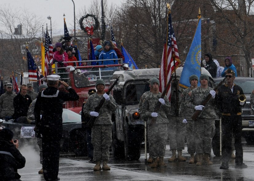 Servicemembers and civilians salute the flag during the Veterans Day parade in Rapid City, S.D., Nov. 11, 2013. During the parade, 50 Airmen marched down Main Street carrying flags representing each state in the U.S. (U.S. Air Force photo by Senior Airman Anania Tekurio/Released)