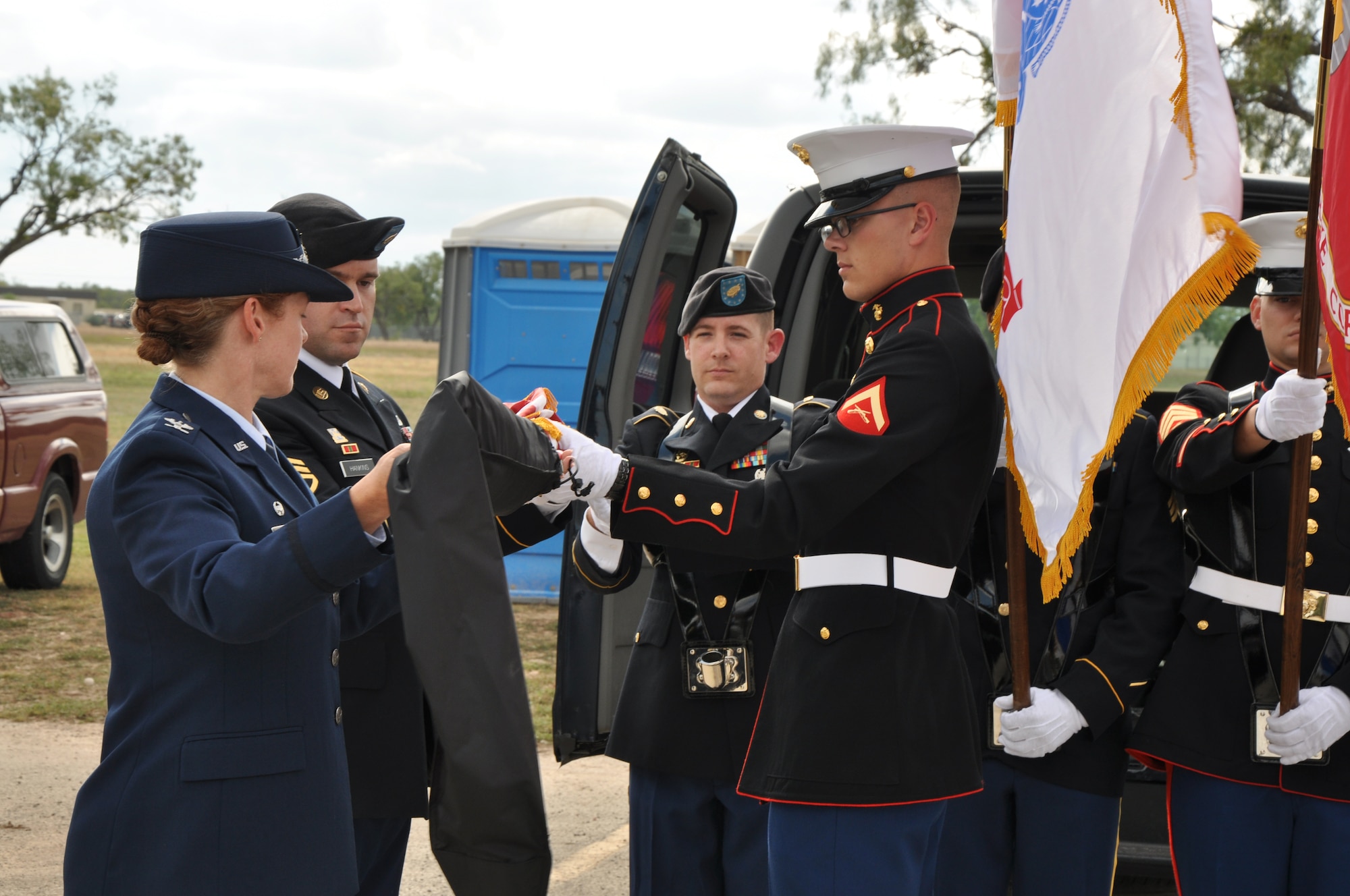 SAN ANGELO, Texas – Col. Kimberlee Joos, 17th Training Wing Commander, assists the Goodfellow Joint Service Color Guard with uncasing the American flag before the Veterans Day observance at the Mathis Field Vietnam Memorial Nov. 11. During the observance Col. Joos spoke about what Veterans Day means to her. (U.S. Air Force photo/ Airman 1st Class Joshua Edwards)
