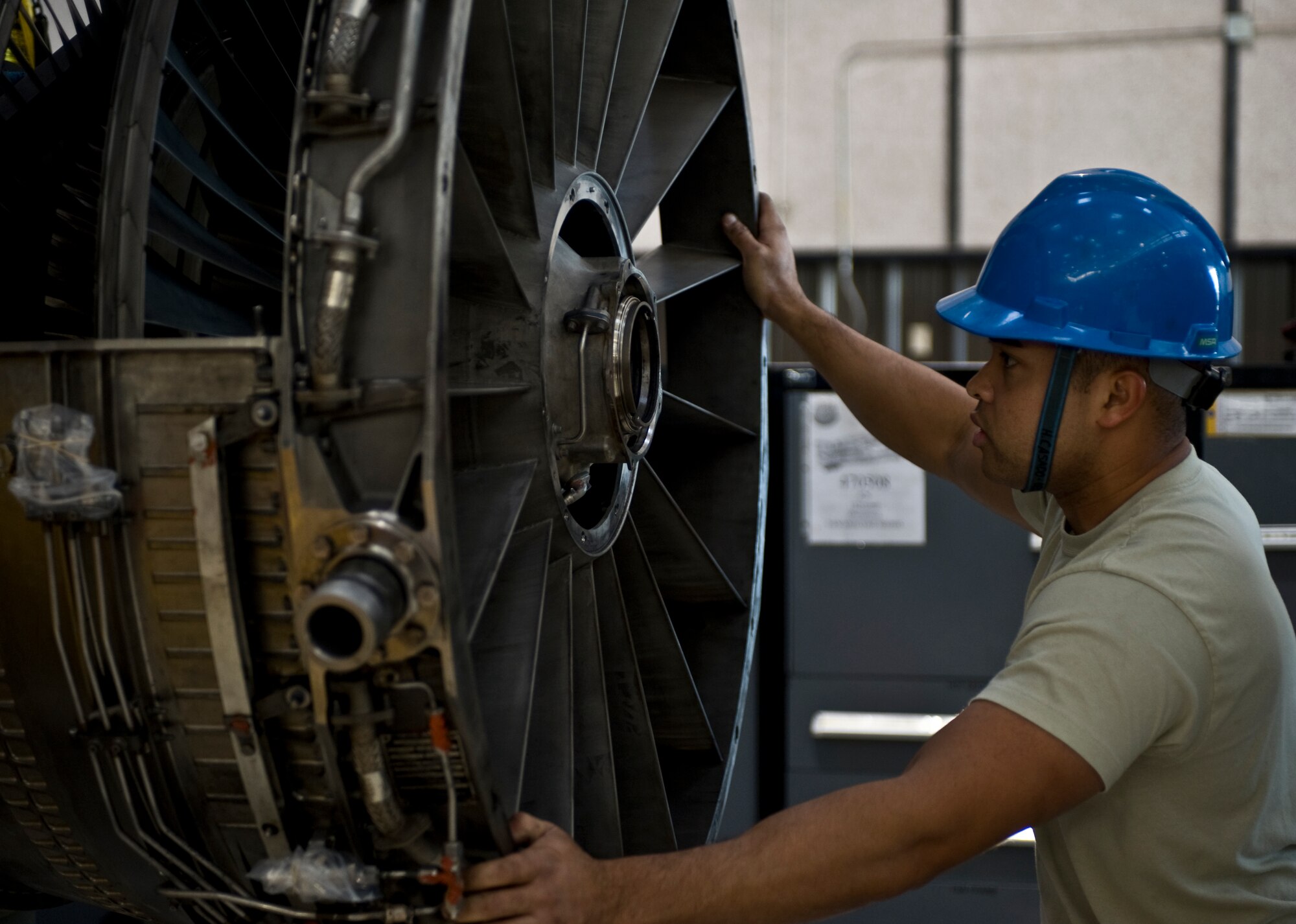 U.S. Air Force Airman 1st Class Hector Casado-Delgado, 7th Component Maintenance Squadron, guides a portion of a General Electric F101-102 turbofan jet engine from a B-1B Lancer on to a repair stand, Nov. 13, 2013, at Dyess Air Force Base, Texas. Casado-Delgado had to separate the larger components of the engine in order to replace some damaged bearings. Each step of the disassembly is listed in a Technical Order that must be followed to ensure each component is properly and safely taken apart. (U.S. Air Force photo by Staff Sgt. Richard Ebensberger/Released)