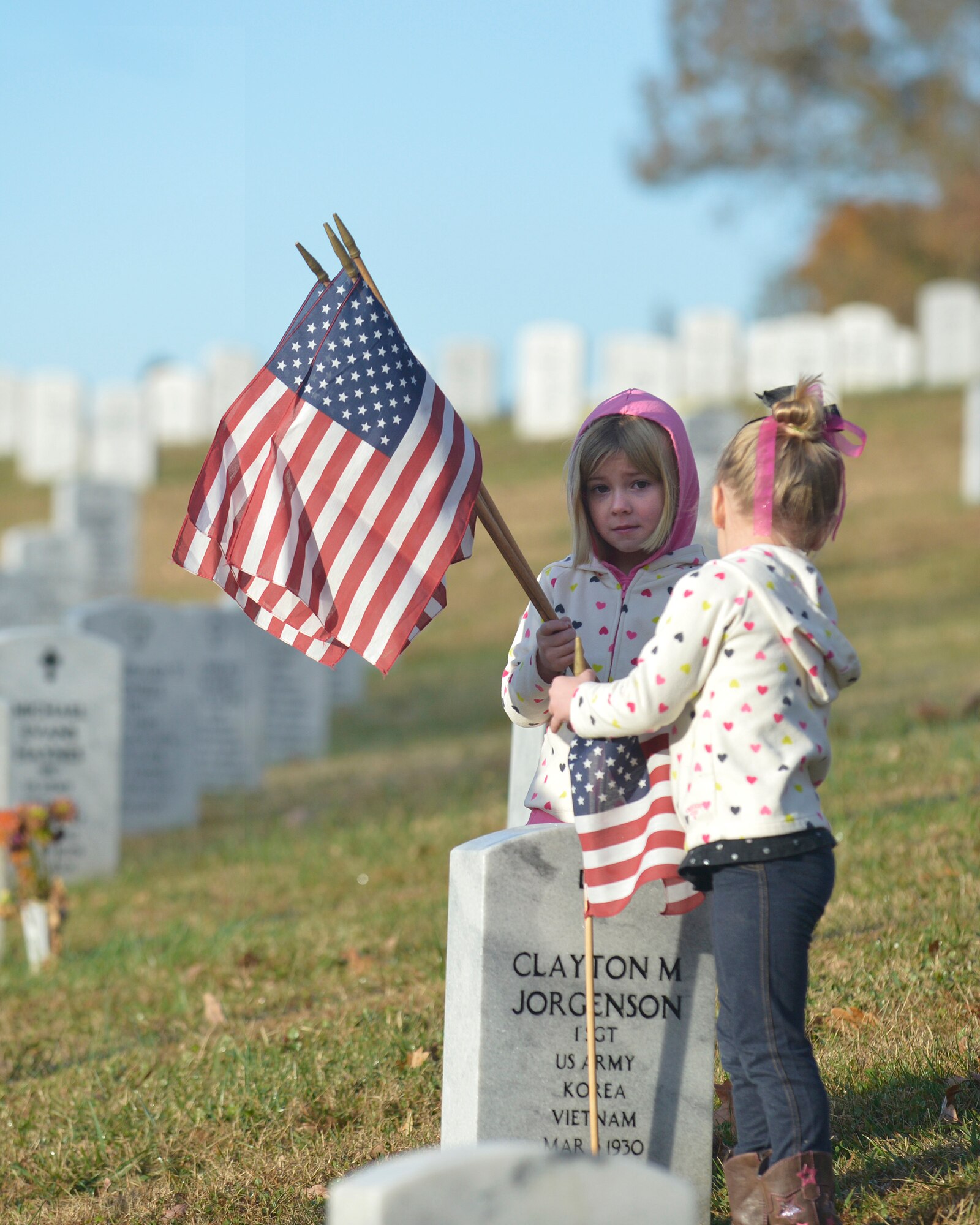 KNOXVILLE, Tenn. - Brooke and Ryleigh, the 4-year-old twin daughters, of Tech. Sgt. Donald Noel, an instructor at the I.G. Brown Training and Education Center, place flags at the Tennessee Veterans' Cemetery, Nov. 9, 2013. (U.S. Air National Guard photo by Master Sgt. Kurt Skoglund/Released)