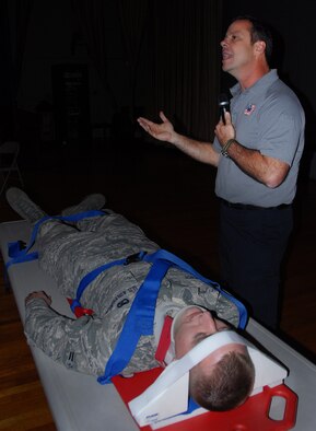 Airman 1st Class Patrick Leach, a member of the 96th Logistics Readiness Squadron, is placed on a spinal board for transportation to a hospital by Ralph Jimenez, a Florida Stay Alive From Education instructor, as part of a car accident victim demonstration during the “Street Smart” program at the Holiday Traffic Safety Campaign Nov. 14.  (U.S. Air Force photo/Kevin Gaddie)
