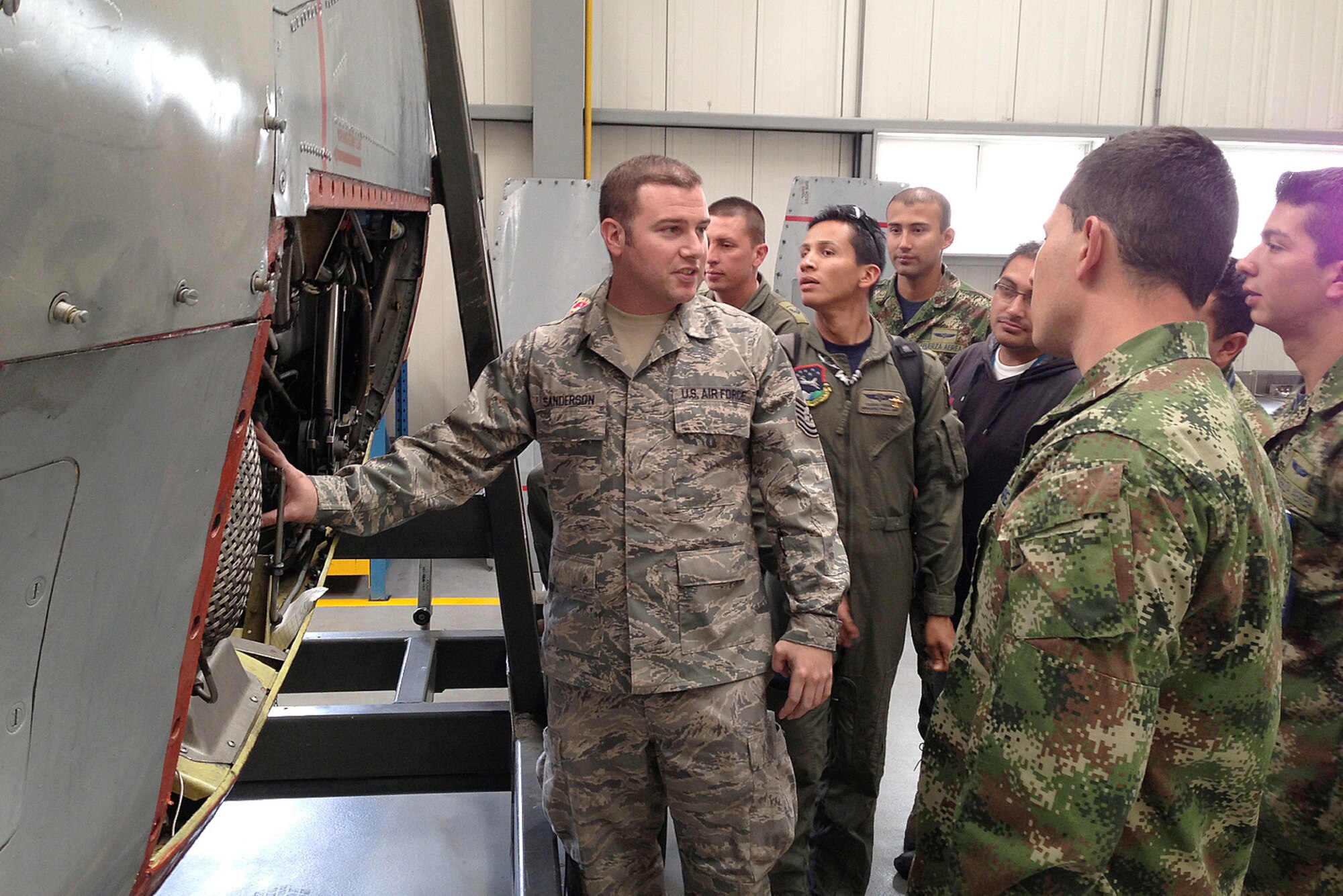 Tech. Sgt Jason Sanderson, a crew chief in the Kentucky Air National Guard’s 123rd Global Mobility Squadron, explains C-130 engine components and inspection procedures to members of the Columbia Air Force during a training event held in Bogota, Columbia, in August and September 2013. (U.S. Air National Guard Photo)