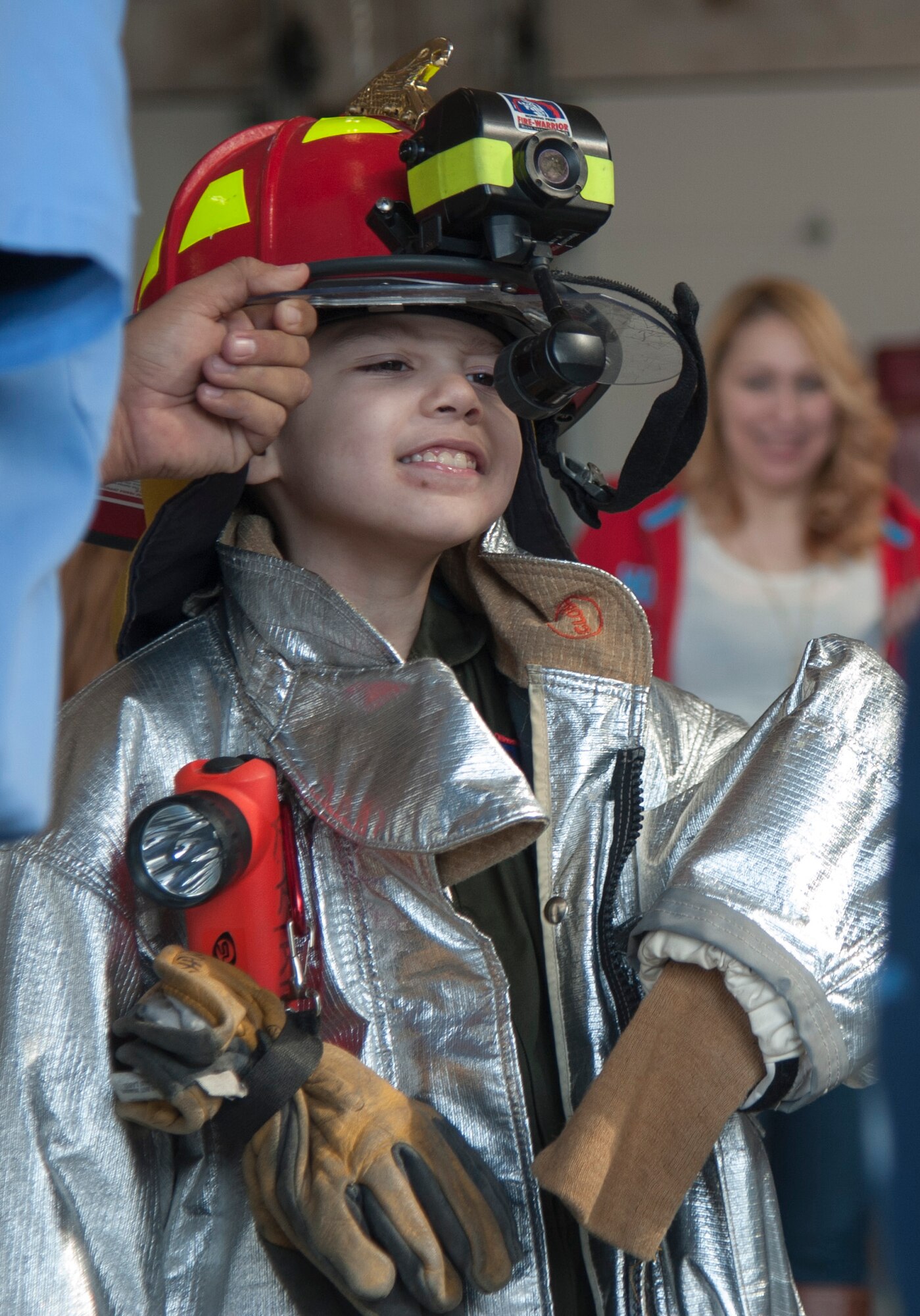 Julian Roque, Laughlin’s honorary Pilot for a Day, dons firefighting equipment during his tour of the fire department on Laughlin Air Force Base, Texas, Nov. 6, 2013. Roque is undergoing rehabilitation for a traumatic brain injury and was chosen to participate in the Pilot for a Day program which allows local children with serious to life-threatening illnesses and their families to tour the base and experience life as a pilot. (U.S. Air Force photo/Airman 1st Class Jimmie Pike)