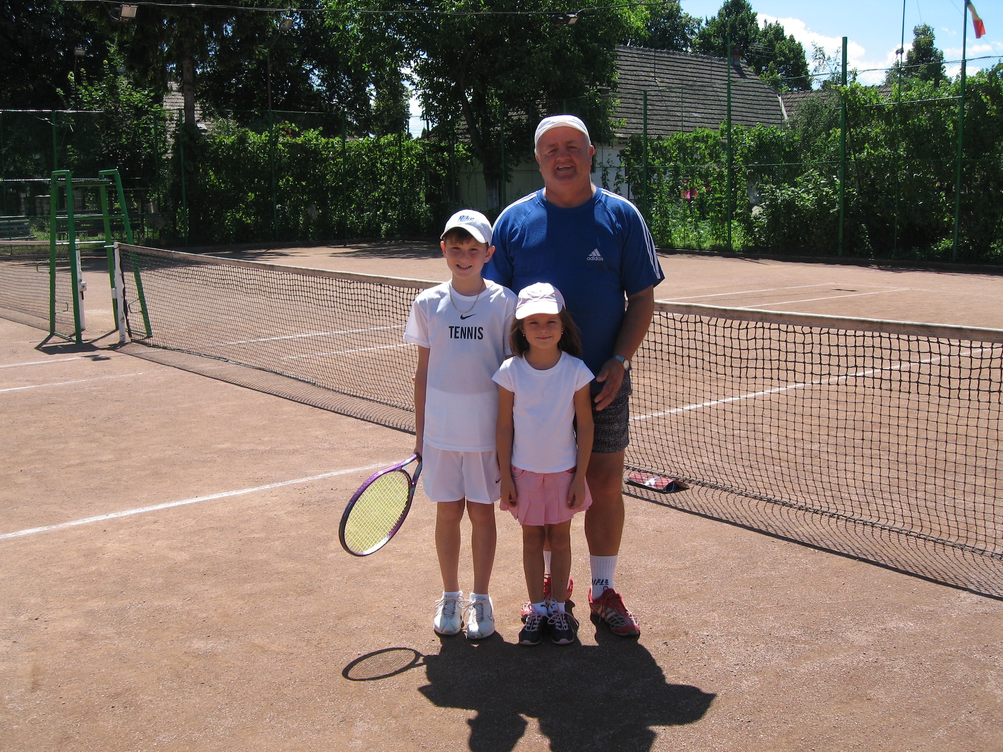 Peter Kovats (left), 10, poses for a picture with his sister, Lydia Kovats, and Nelu Vajda, head coach of the Campia Turzii Tennis Club, during summer vacation on a tennis court in Campia Turzii, Romania, in 2007. Kovats has been playing tennis since he was 8 years old and recently won the DODDS-Europe tennis championship by defeating Fabian Sandrup Selvik from the International School of Brussels, 6-2, 6-3. (Courtesy Photo)
