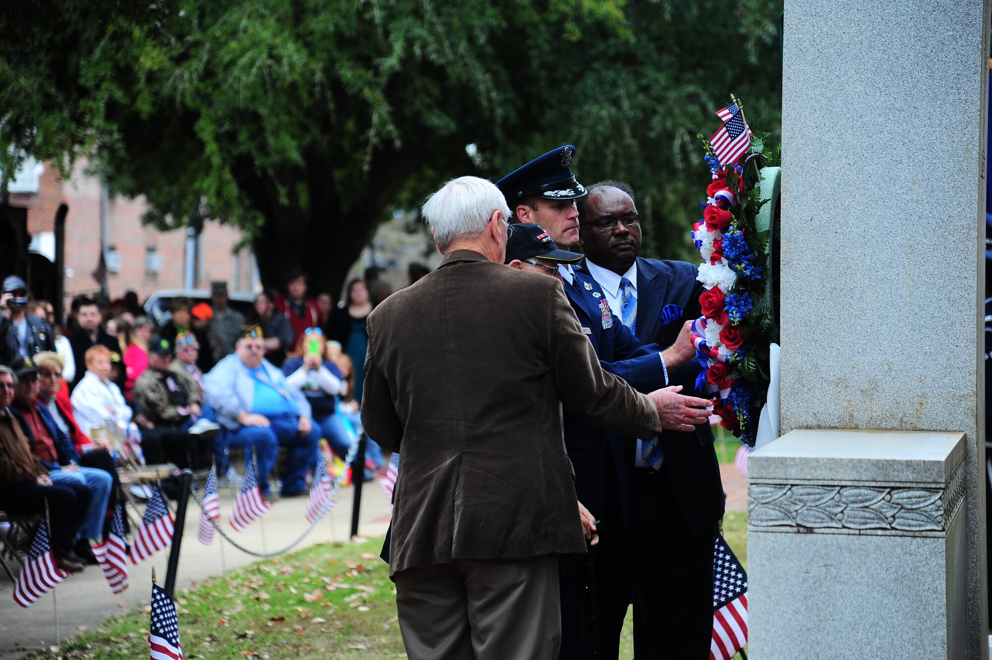 Col. Jim Sears, 14th Flying Training Wing Commander, alongside the oldest veteran (retired) Lt. Col. Bob Gilbert and Mayor Robert Smith of Columbus, Miss. and Mr. Harry Sanders, President of the Board of Supervisors hang a wreath on the memorial outside the Lowndes County Courthouse Nov. 9. (U.S. Air Force Photo/Airman 1st Class Stephanie Englar)