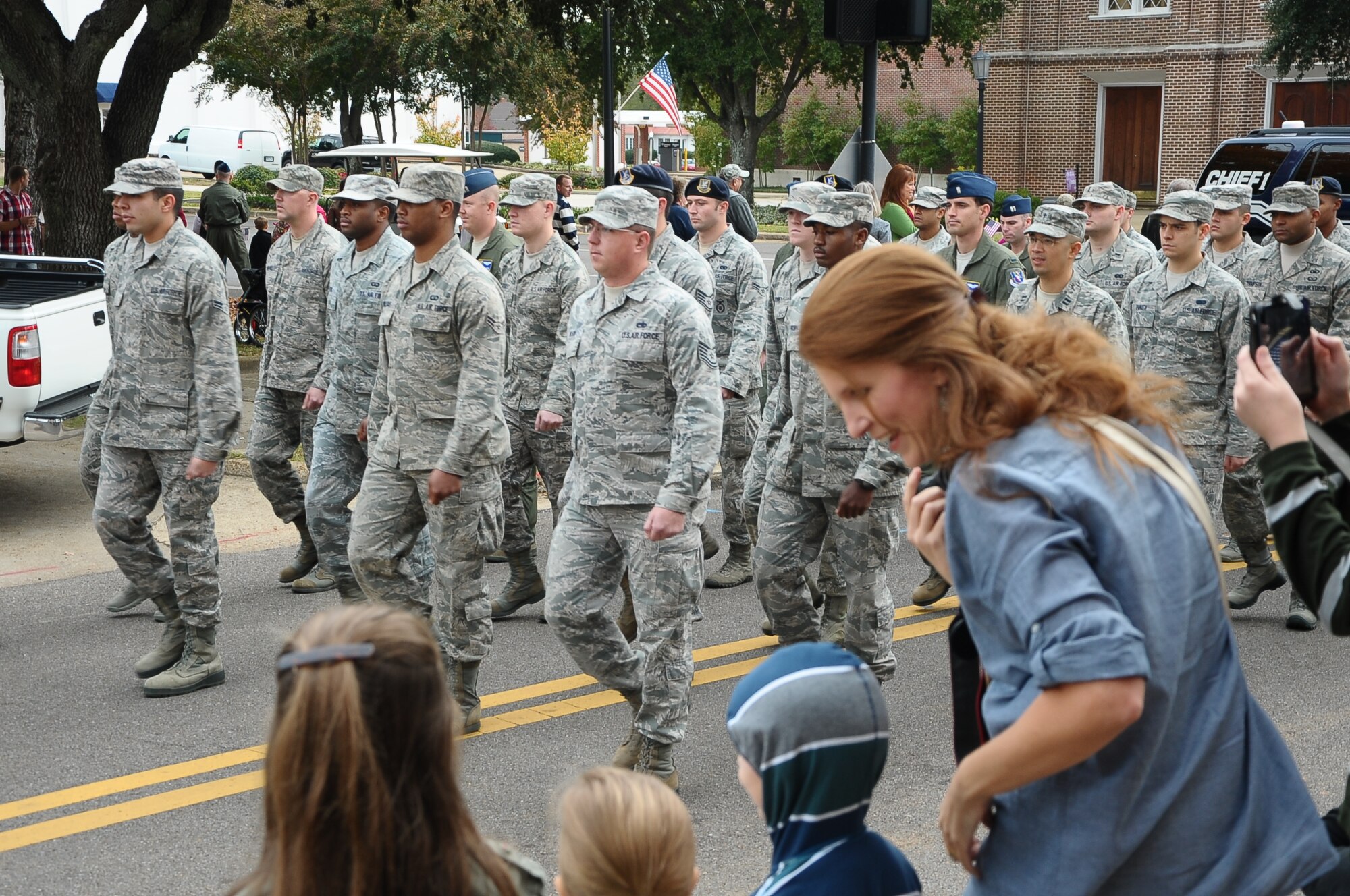 Spectators watch as a formation of over 50 Airman march in cadence down Main Street at the Veterans Day Parade and Ceremony Nov. 9. (U.S. Air Force Photo/Airman Daniel Lile)