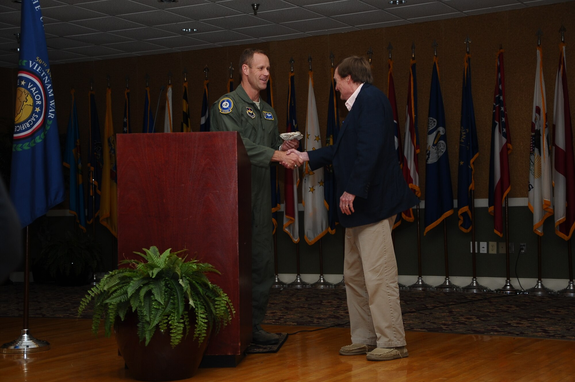 Col. Jim Sears, 14th Flying Training Wing Commander, hands a piece of the old center runway to Rufus Ward, Columbus, Miss. native and local historian, at a Base Community Council luncheon Nov. 8 at the Columbus Club. Rufus Ward, the guest speaker at the event, normally divides his time between consulting and lecturing on cultural history and writing a weekly history column for the Columbus Commercial Dispatch. (U.S. Air Force Photo/Airman Daniel Lile)