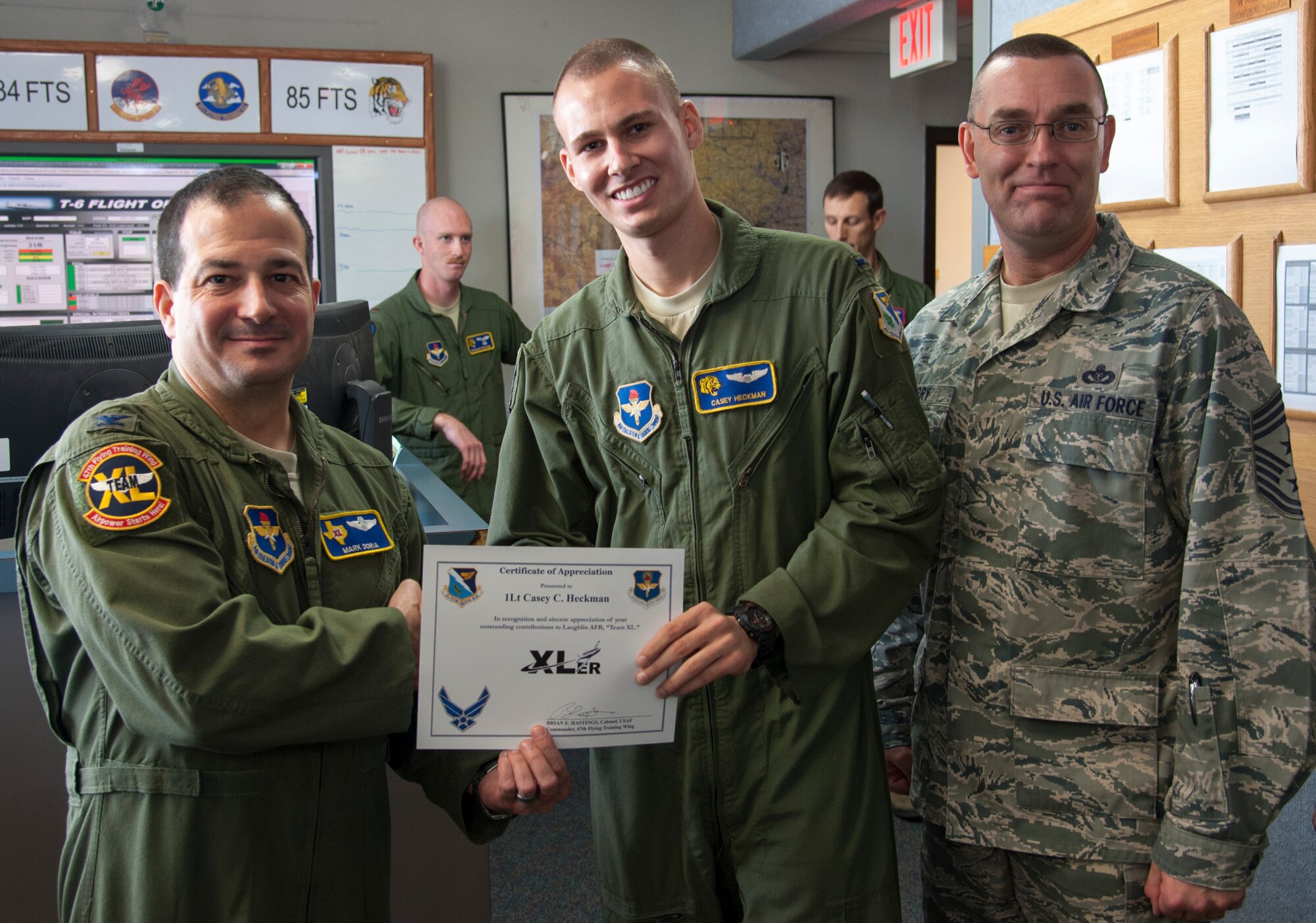 1st Lt. Casey Heckman, center, 85th Flying Training Squadron chief scheduler, poses with Col. Mark Doria, left, 47th Flying Training Wing vice commander, and Chief Master Sgt. Garry Berry, 47th FTW command chief, after being presented the XLer of the week award here Nov. 6, 2013. The XLer is a weekly award chosen by wing leadership and given to those who consistently make outstanding contributions to Laughlin and their unit. (U.S. Air Force photo/Senior Airman John D. Partlow)