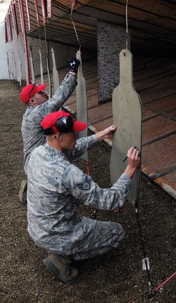 YOUNGSTOWN AIR RESERVE STATION, Ohio—U.S. Air Force Reserve Staff Sgt. Brandon Benes and Senior Airman Patrick Edmonds, Combat Arms Instructors with the 910th Combat Arms Training and Maintenance (CATM), score targets at the end of a M9 qualification session here, Nov. 3, 2013. CATM works year-round to ensure Service members are highly trained and qualified on various weapons systems. (U.S .Air Force photo/ TSgt Rick Lisum)