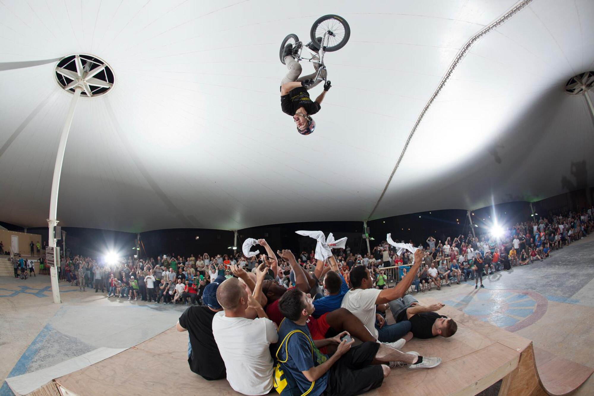 Drew Bezanson backflips over service members during a Bikes Over Baghdad demonstration at the 379th Air Expeditionary Wing in Southwest Asia, Nov. 9, 2013. Bezanson is a professional BMX rider with the Bikes Over Baghdad group and competes in X-games competitions worldwide. (Courtesy photo by Keith Mulligan)